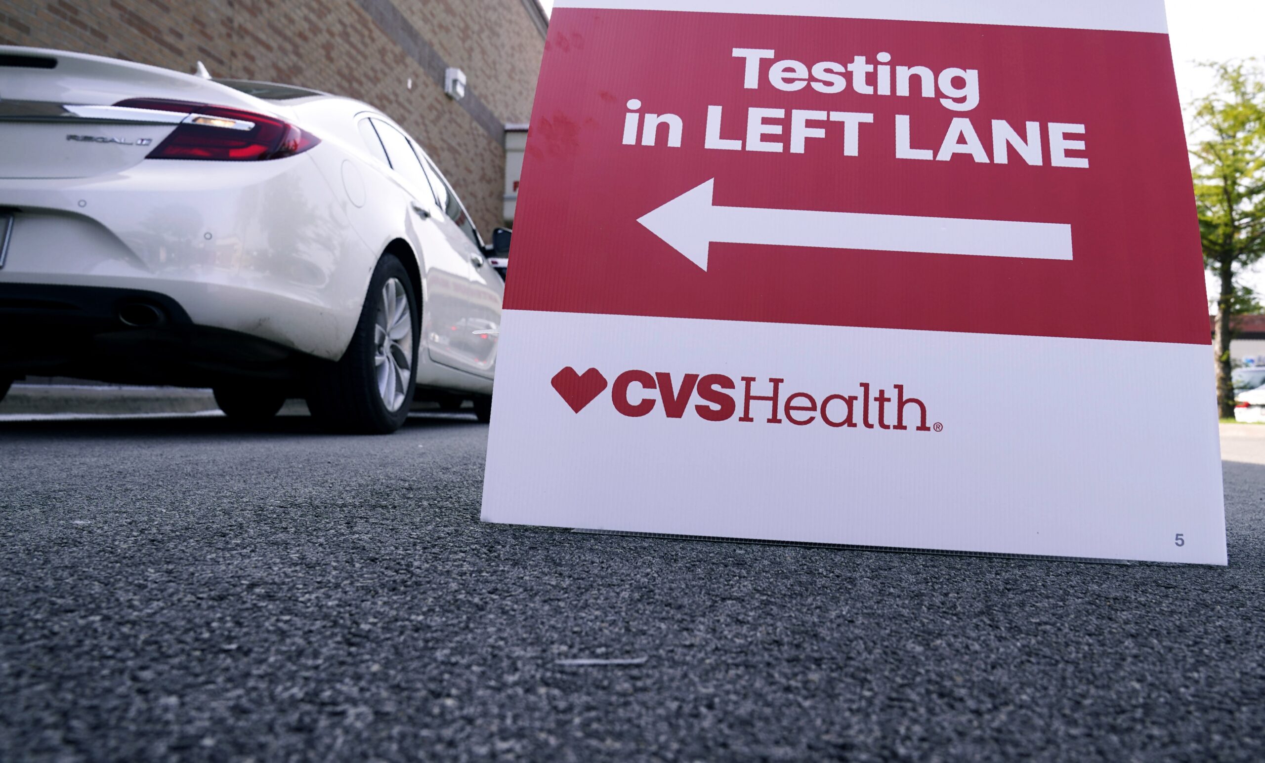 Cars wait in line at a CVS pharmacy offering drive-thru COVID-19 nasal swab tests