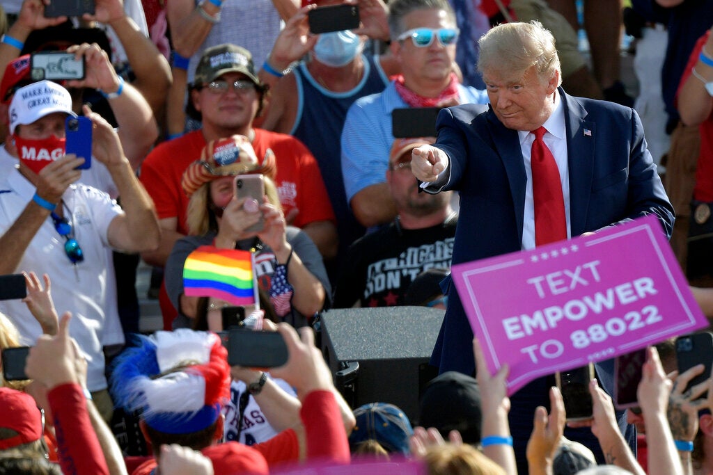 President Donald Trump points to supporters after arriving for a campaign rally in Ocala, Florida