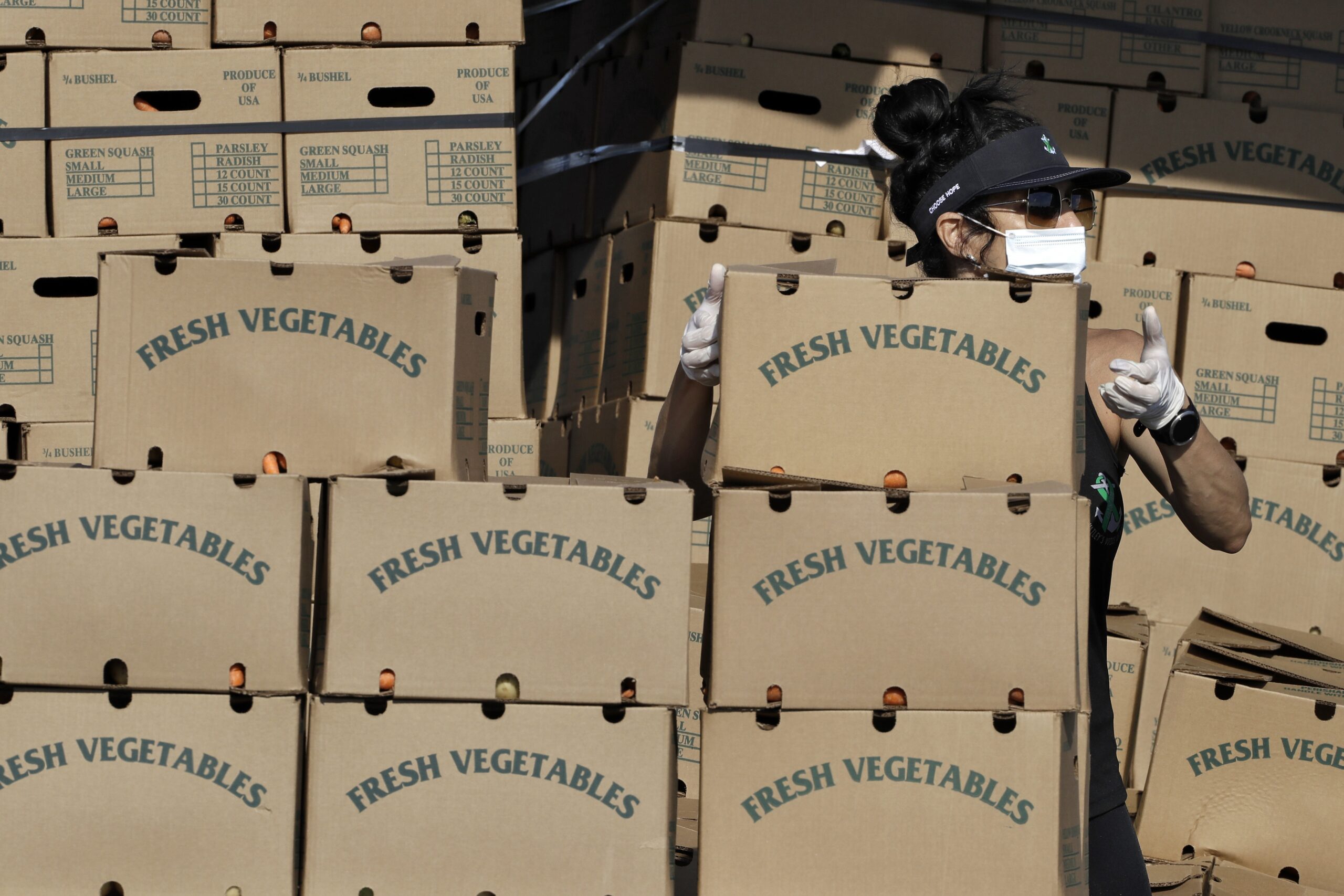 A volunteer grabs a box of food