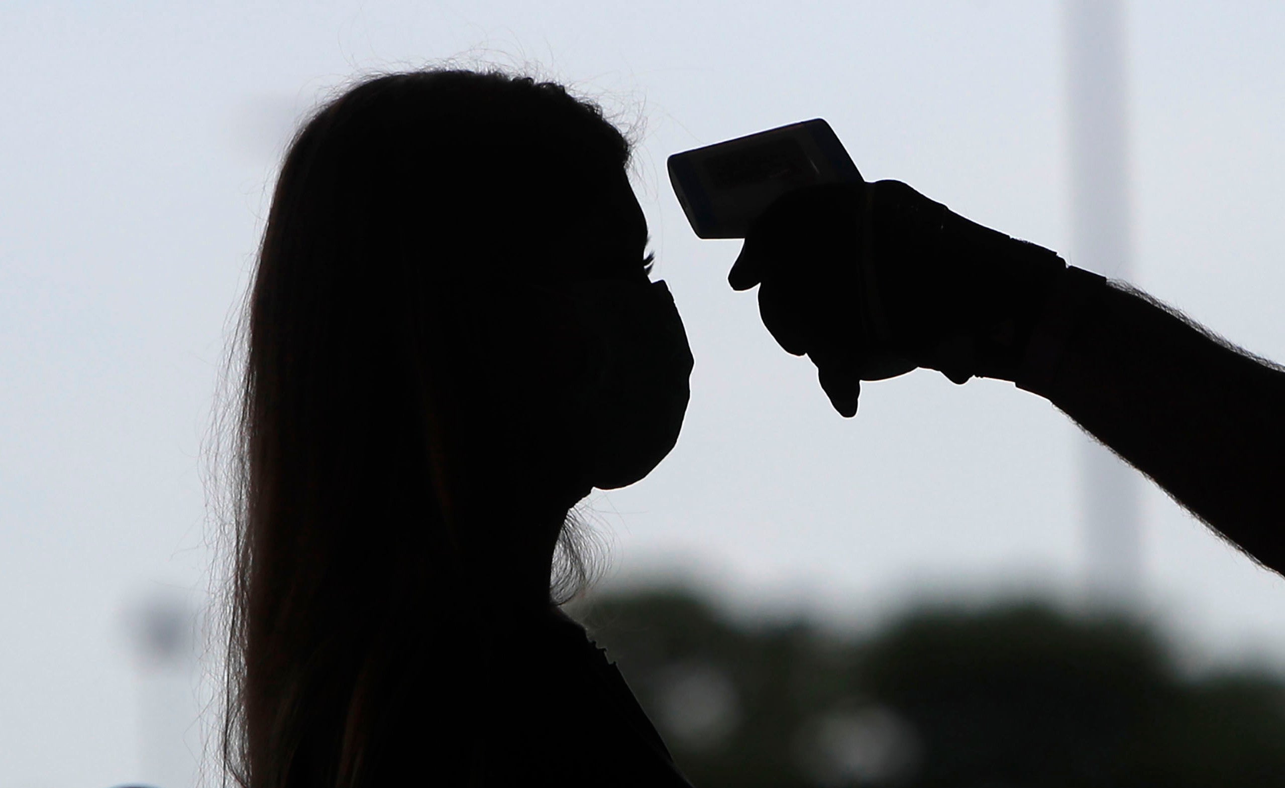 a woman has her temperature checked
