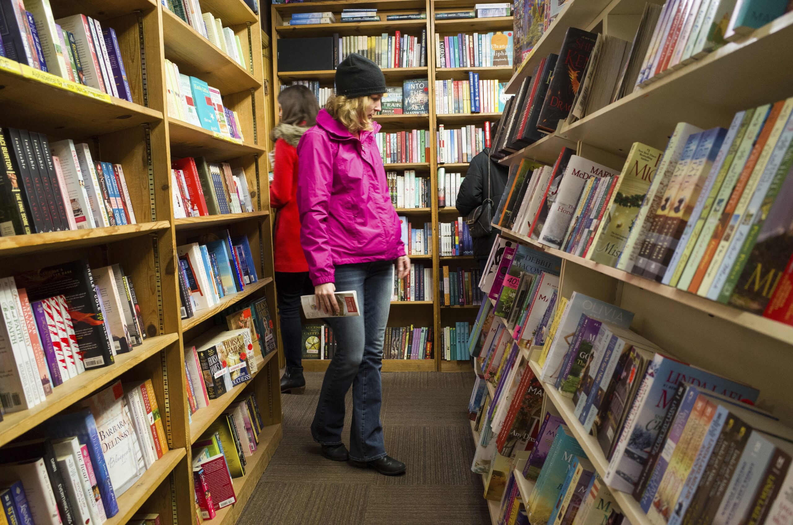 Shoppers browse among narrow rows of books