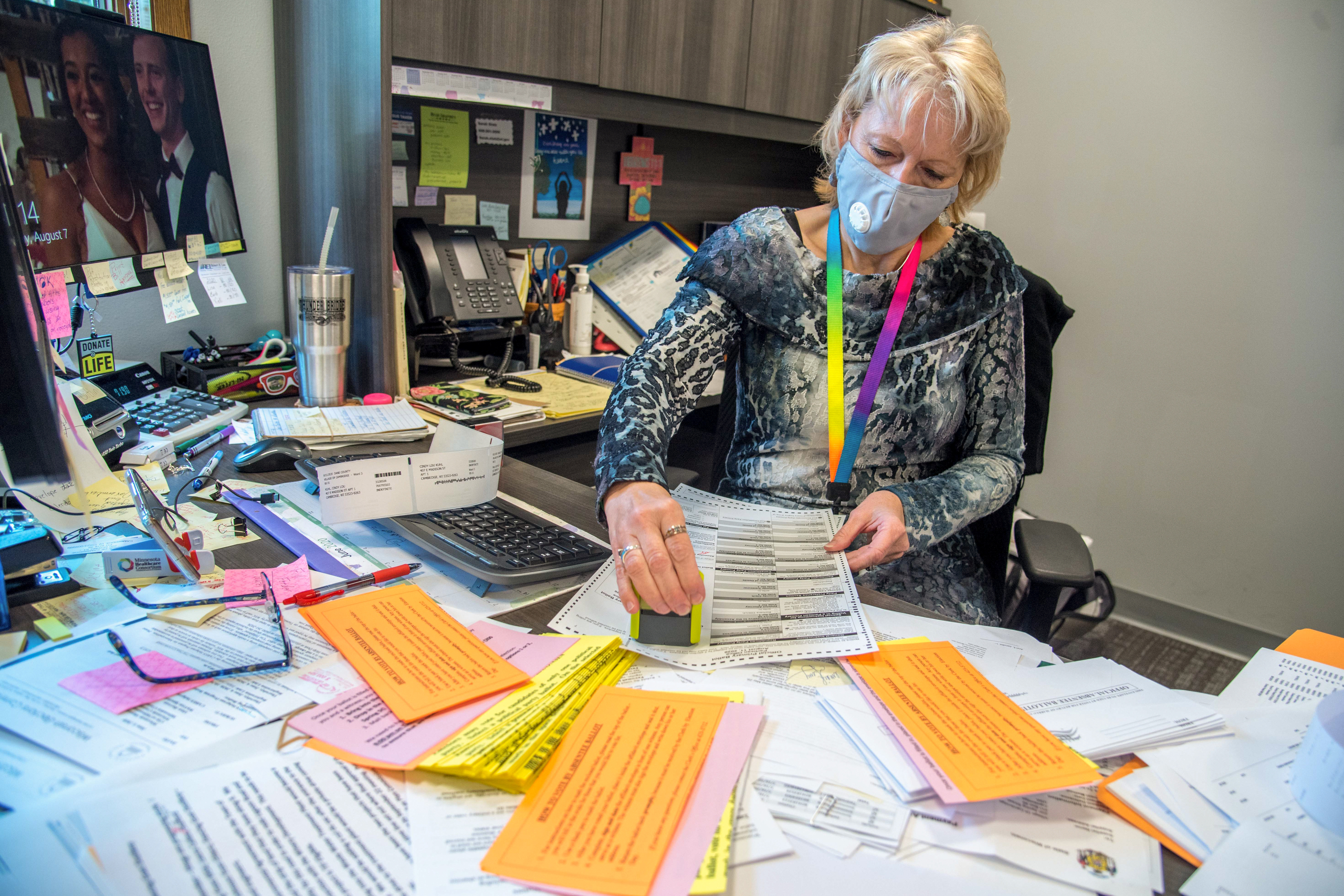 Deputy Clerk Barb Goeckner prepares outgoing absentee ballot envelopes for voters