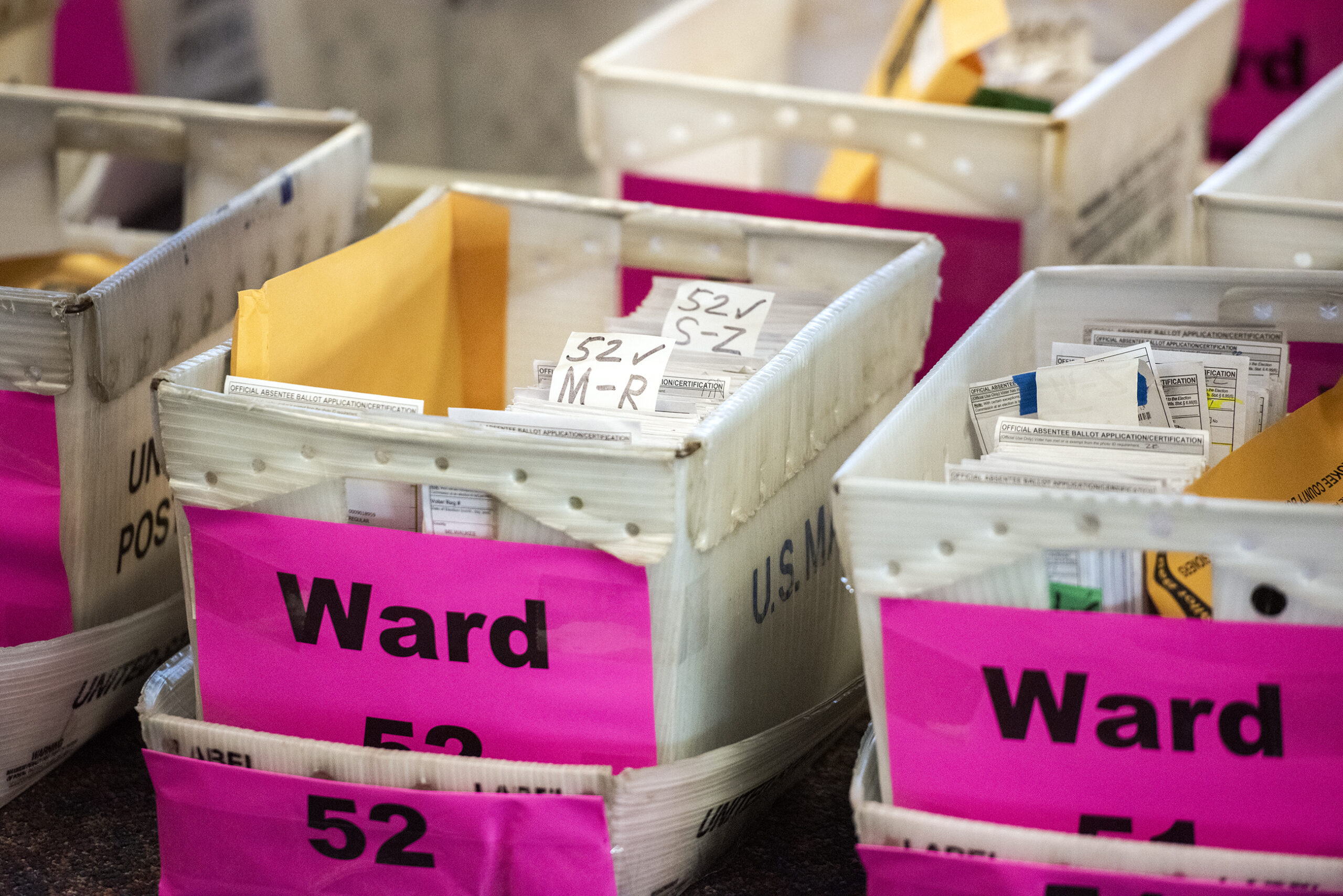 white boxes filled with ballots are labeled with ward numbers