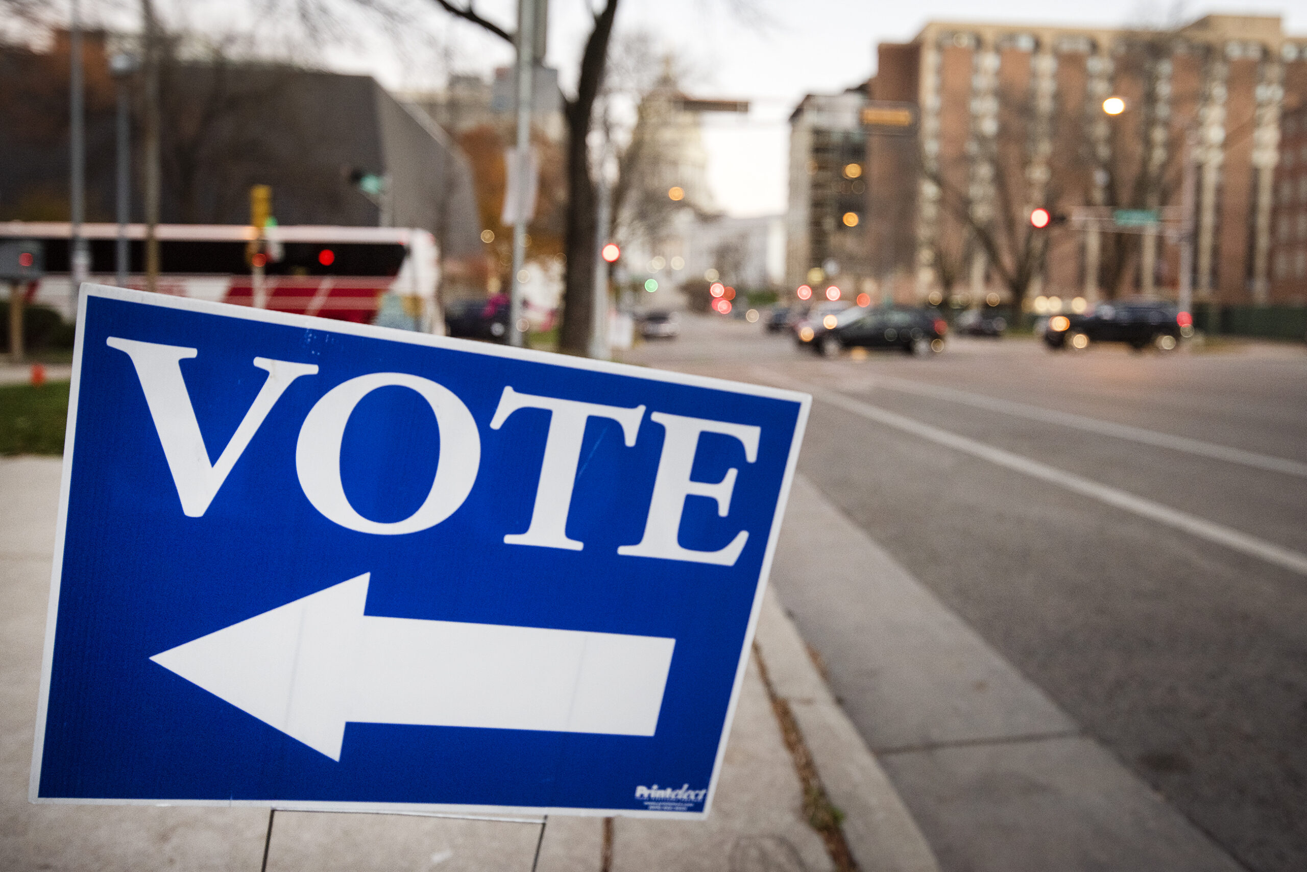 a blue sign says "VOTE" with an arrow