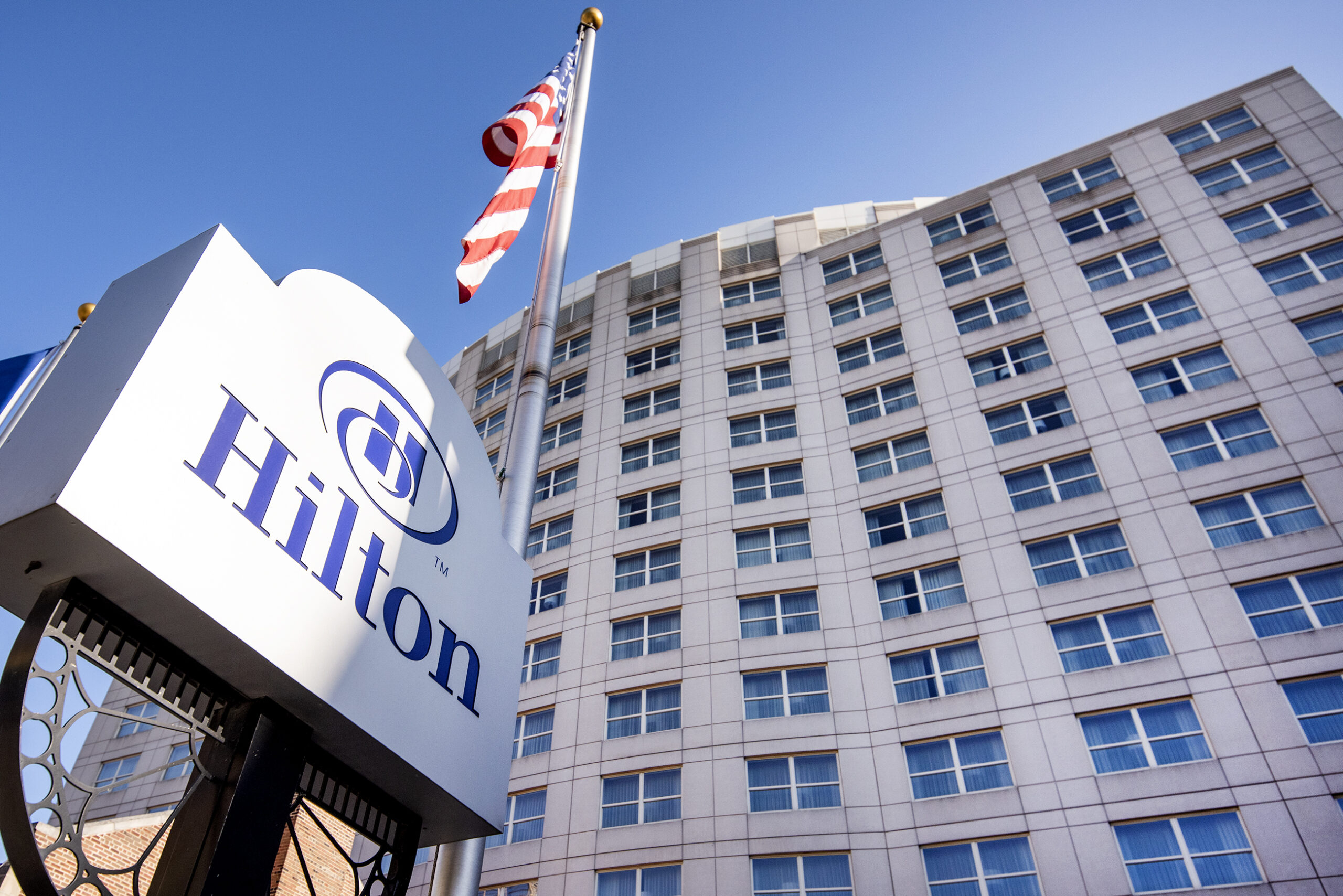 A sign that says "Hilton" can be seen in front of a tall building