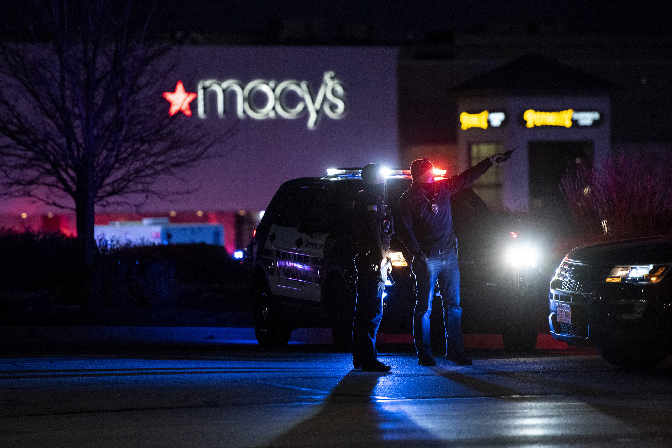 Two officers point as police light up a nighttime crime scene