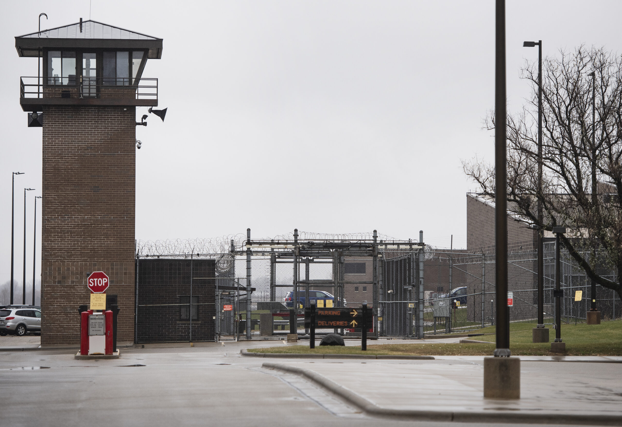 A large fence and observation tower can be seen across a parking lot