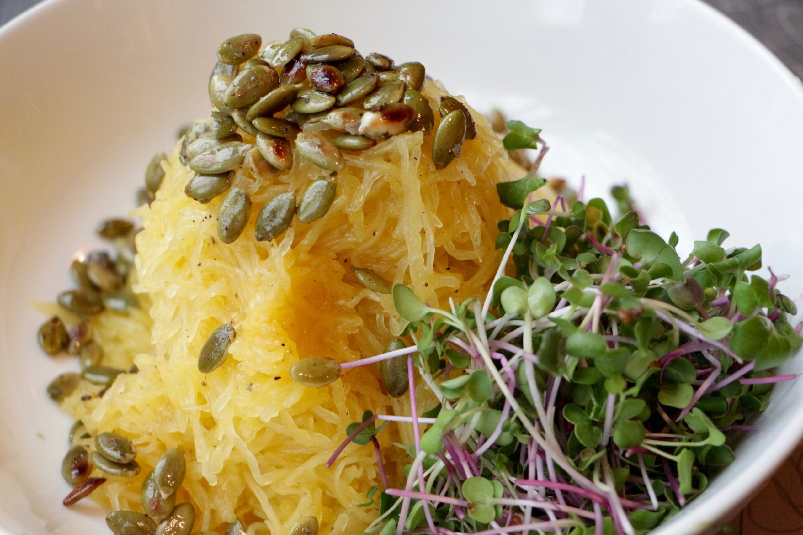 Spaghetti Squash and microgreens with toasted pumpkin seeds on top.