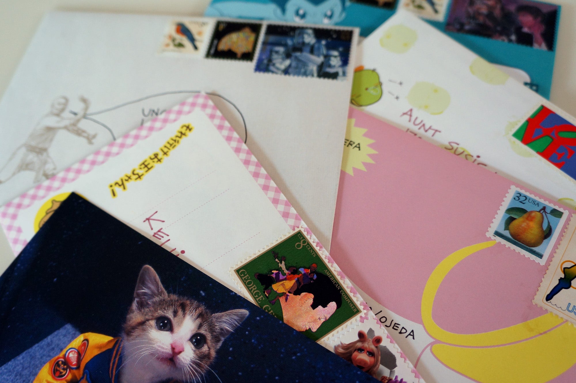 A pile of letters and postcards waiting to be mailed.