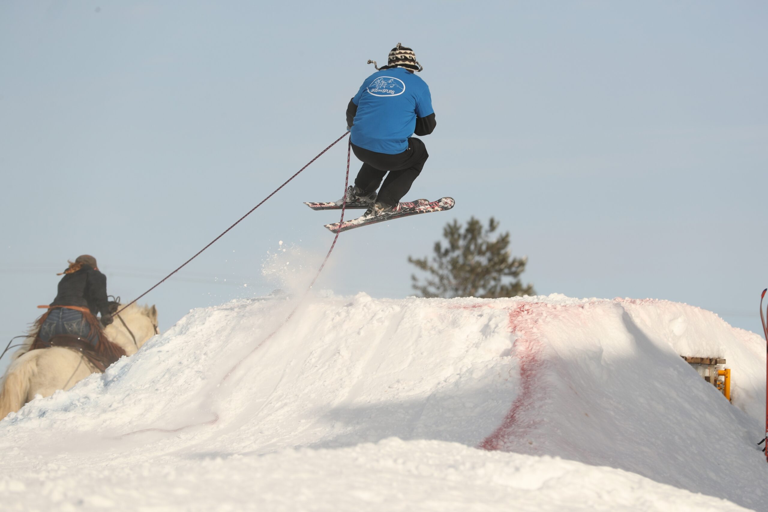 Skier being pulled by a horse hits a jump at The Spurs & Skis Skijoring Stampede in Rice Lake​​​​​​​. 