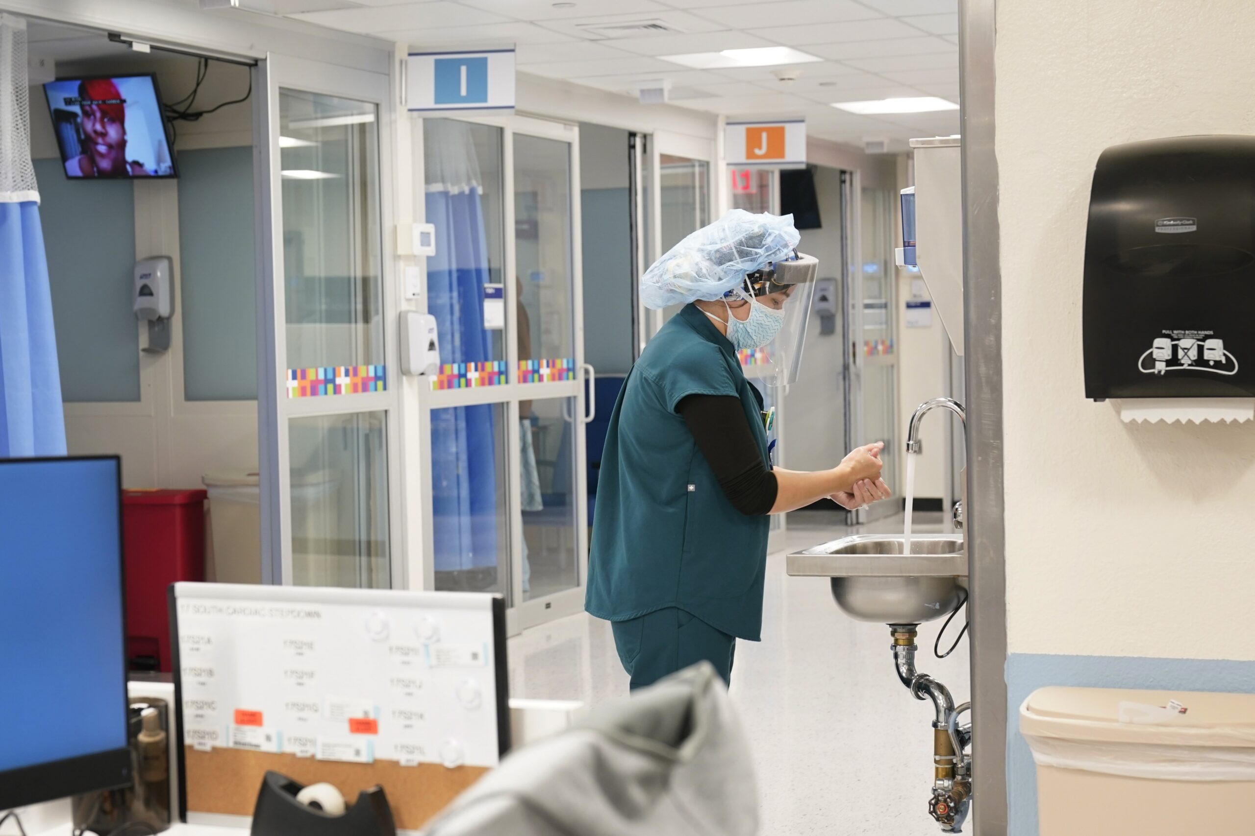 Medical personnel wash their hands while tending to patients