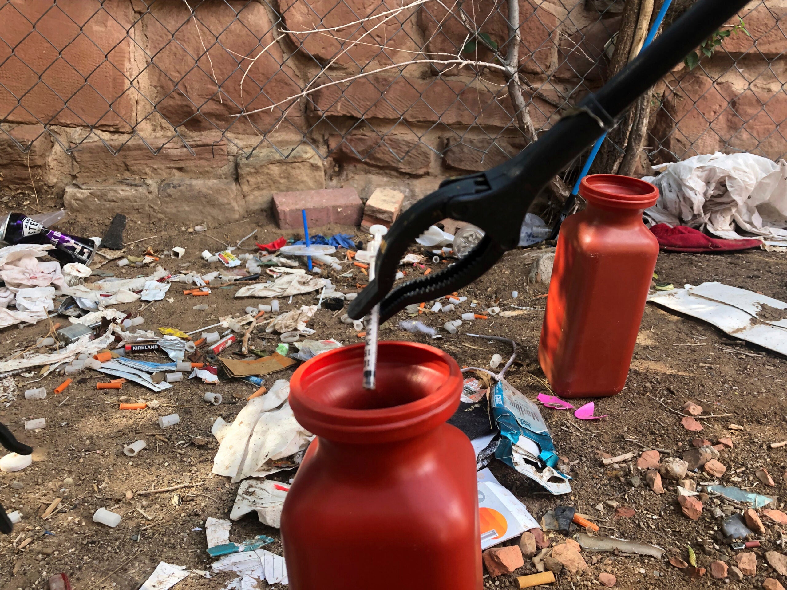 A drug syringe being picked up