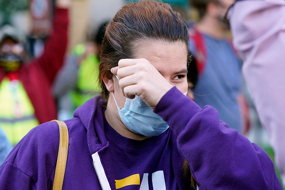A person wipes a tear as they watch Election results near the White House