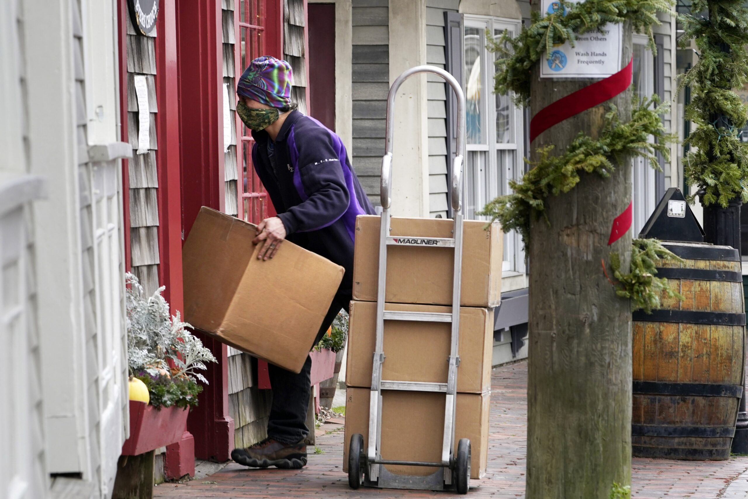 A Fed-Ex worker wearing a facemask makes a delivery