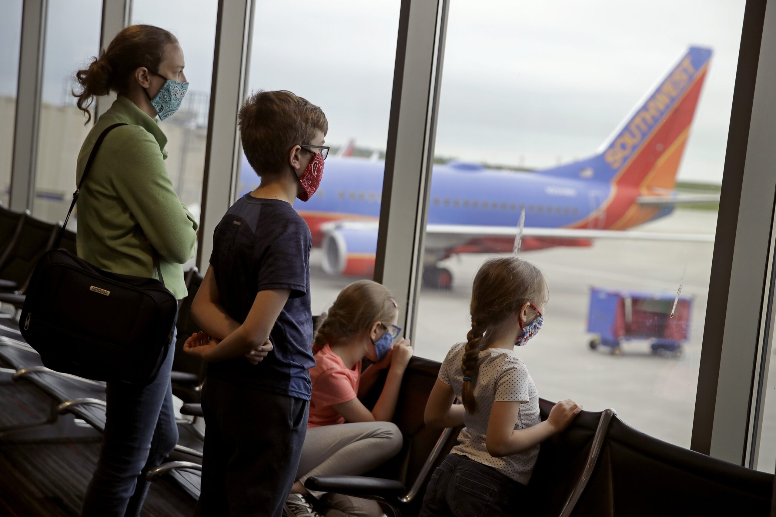 A family wearing masks waits to board a Southwest Airlines flight