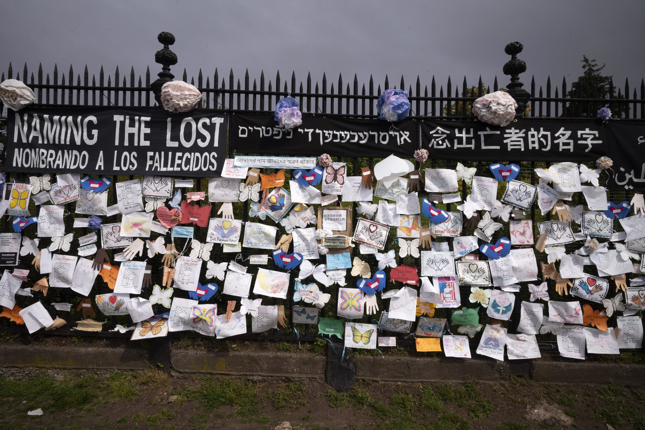 Names of people who have died from COVID on a fence in Brooklyn, New York