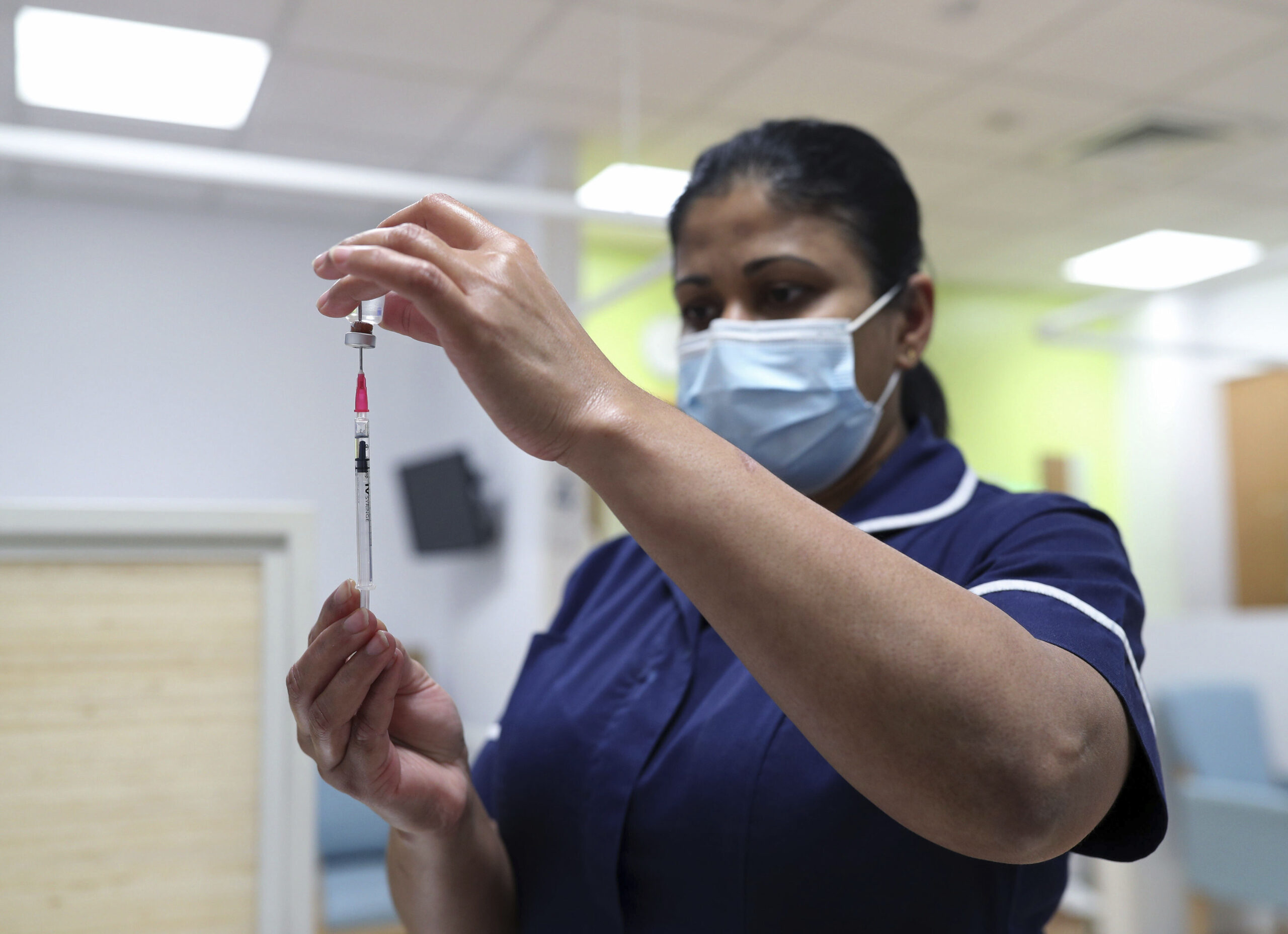 A nurse simulates administration of the Pfizer vaccine