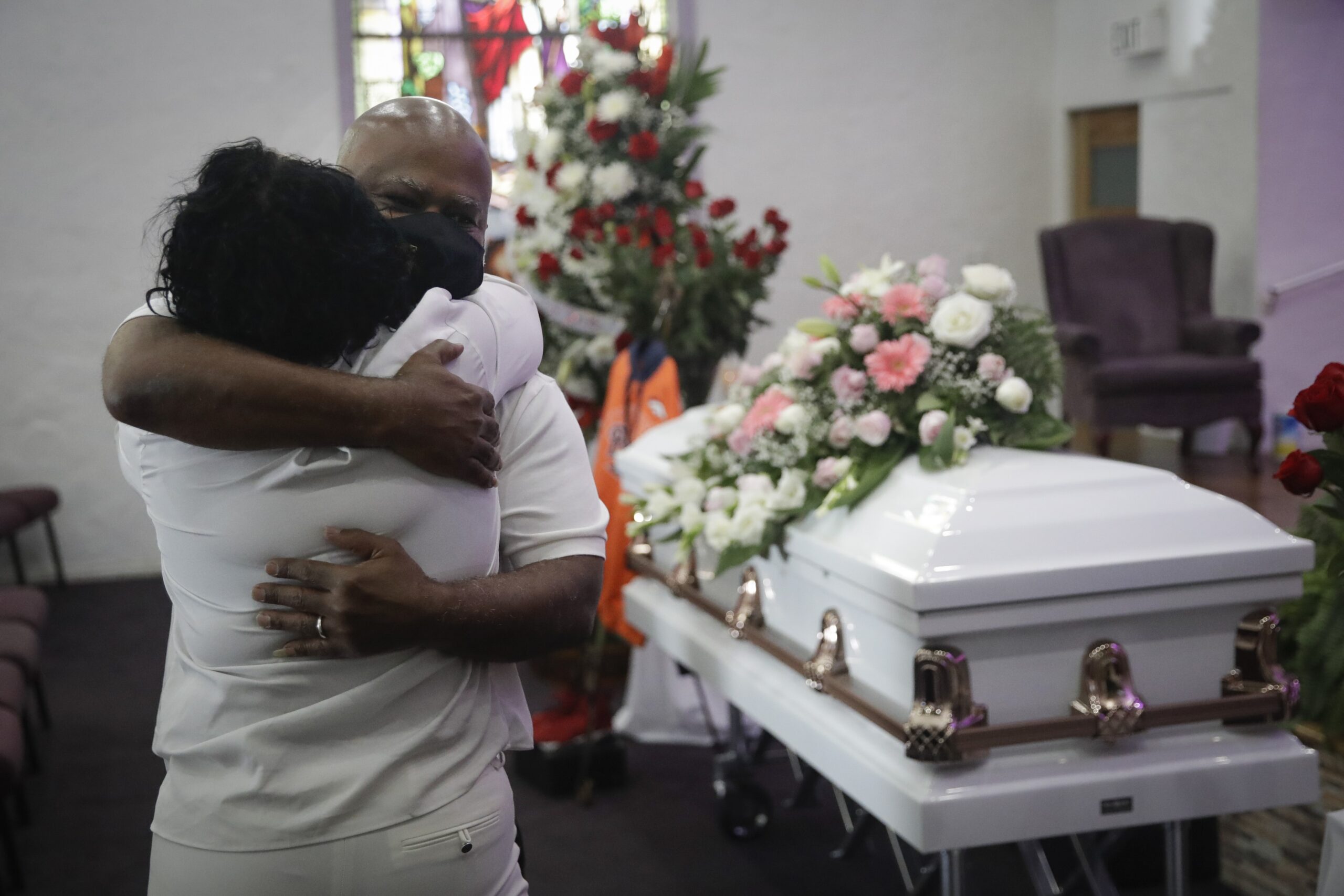 In this July 21, 2020, file photo, Darryl Hutchinson, facing camera, is hugged by a relative during a funeral service for Lydia Nunez