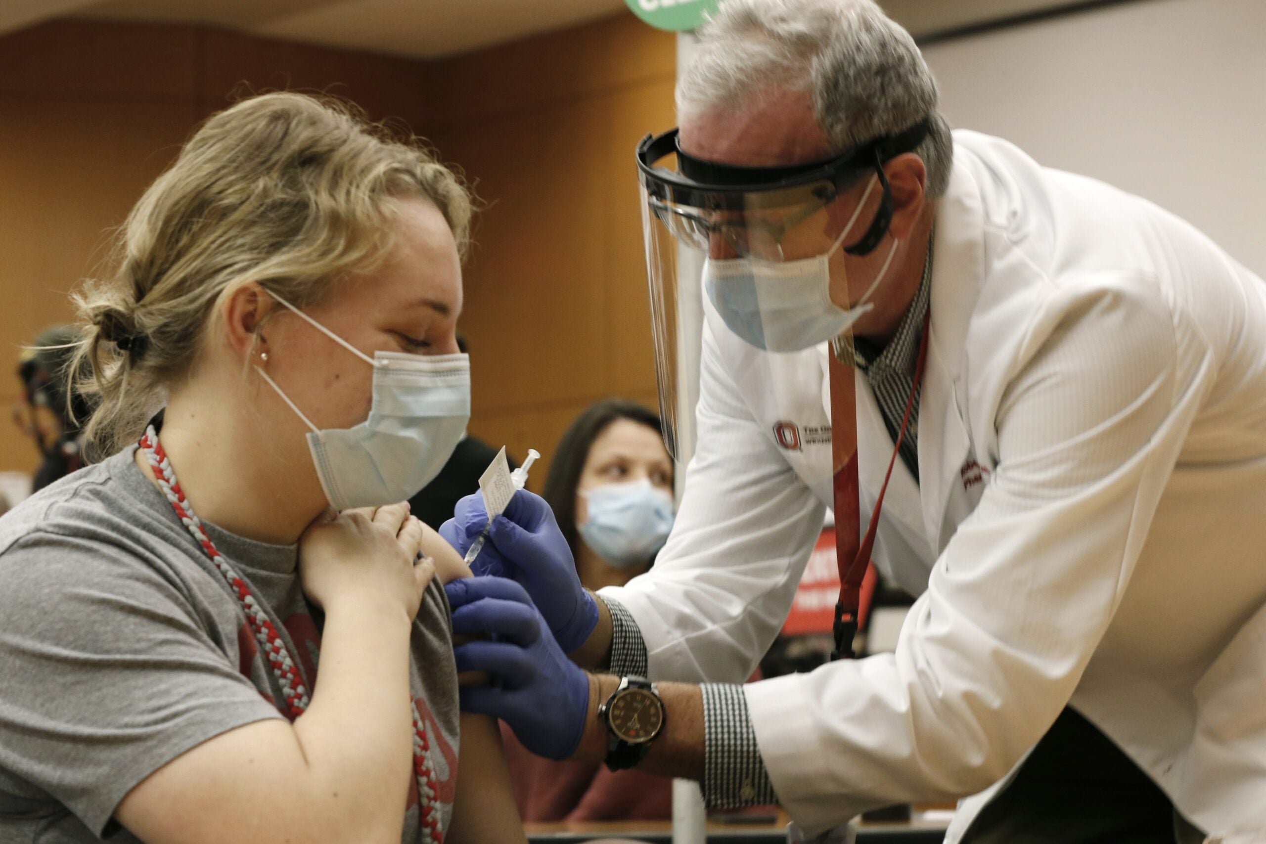 A woman receives a vaccine from a doctor