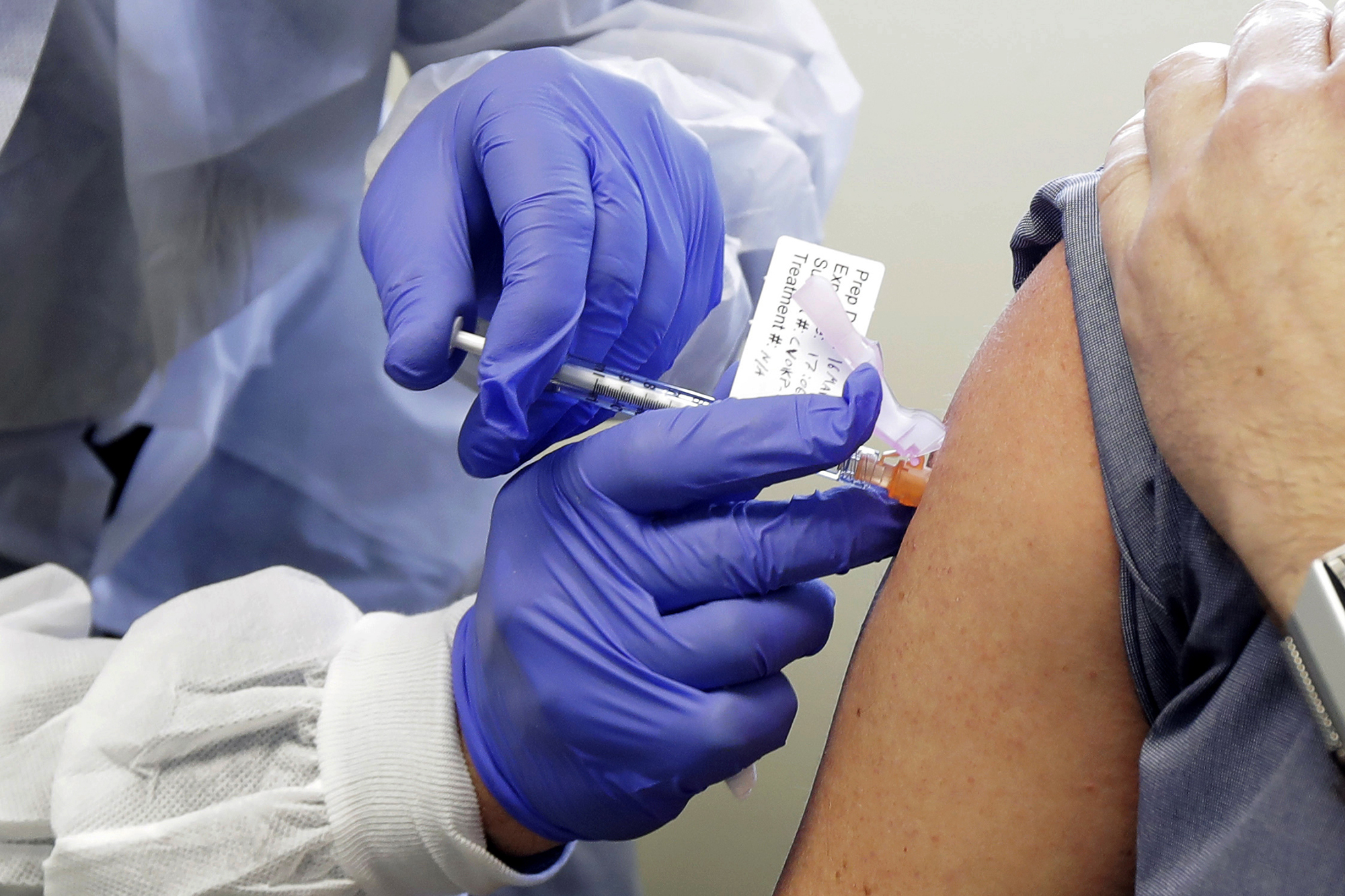 A patient receives a shot in the first-stage safety study clinical trial of a potential vaccine for COVID-19