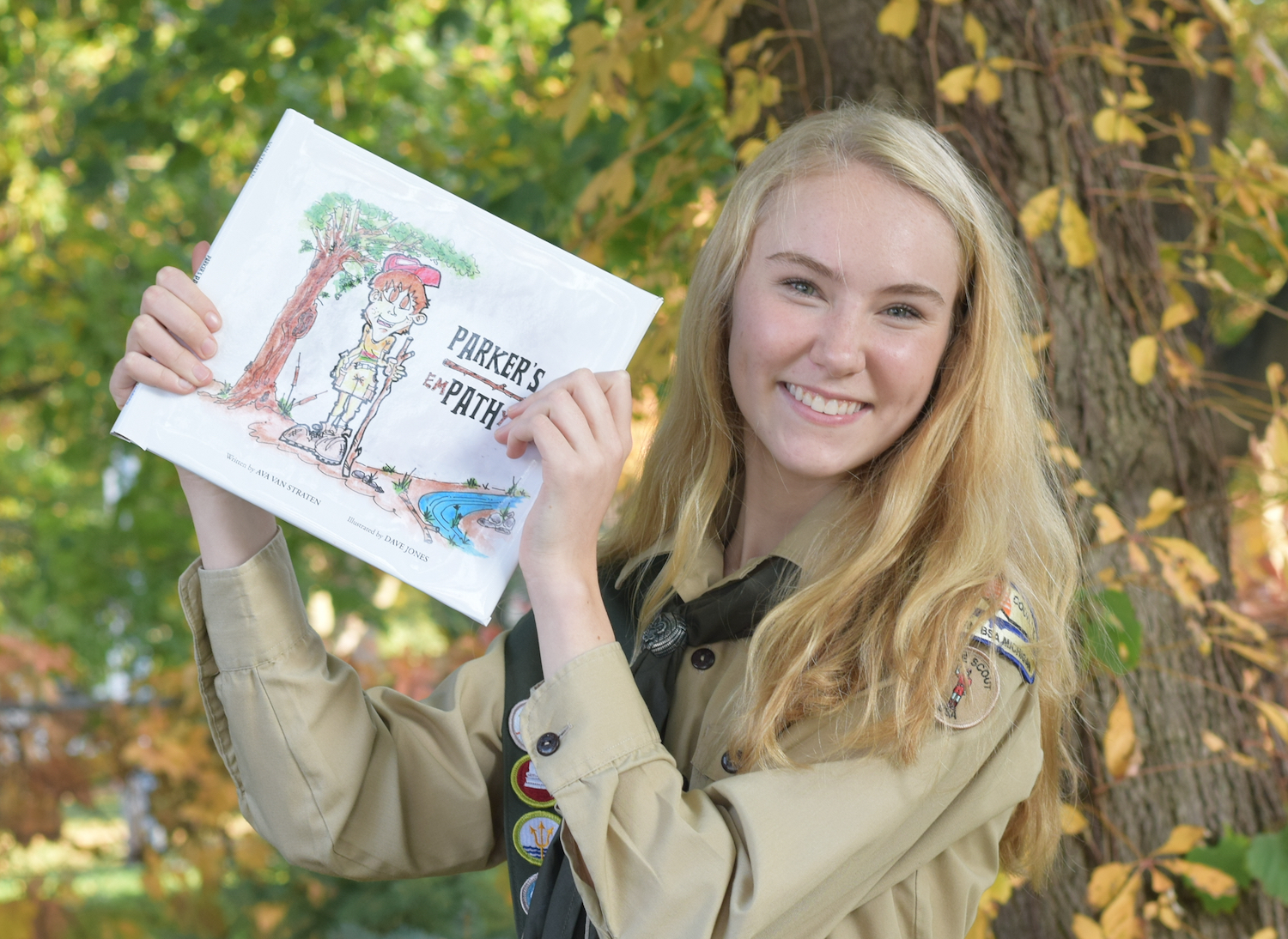 Ava Van Straten poses with the children's book she wrote for her Eagle Scout project
