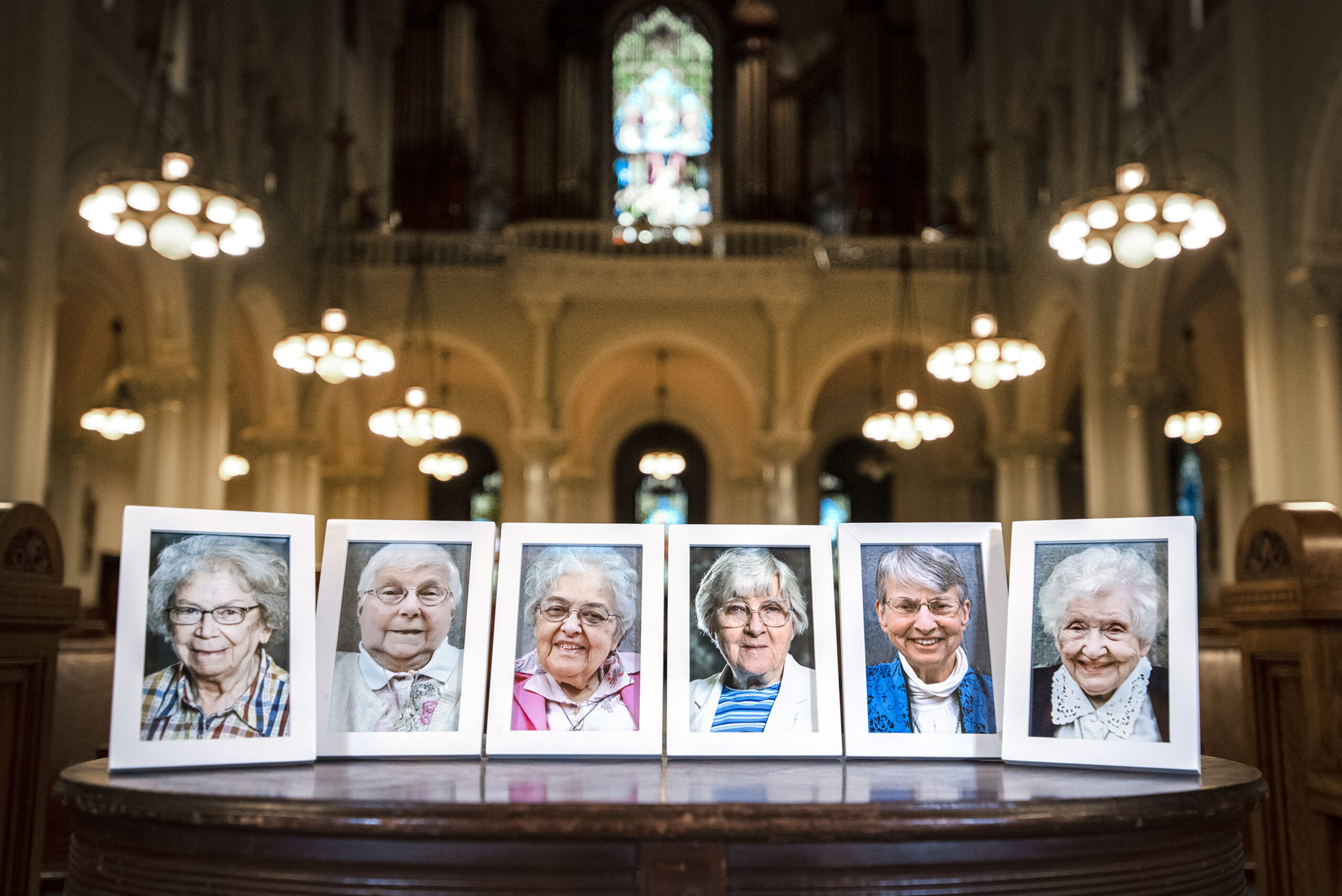 six framed photos of nuns are seen inside of a chapel