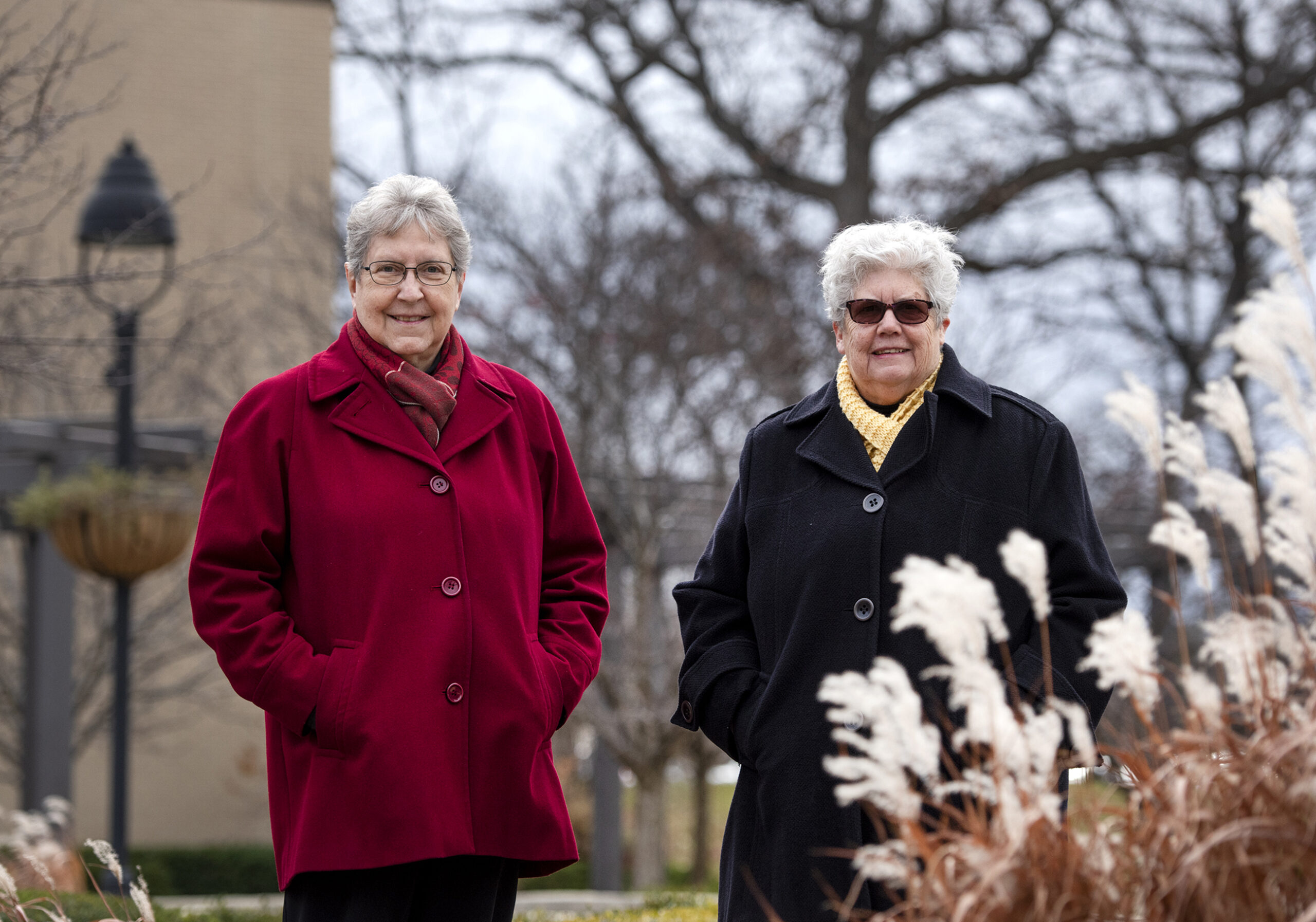 two women in coats stand outside together