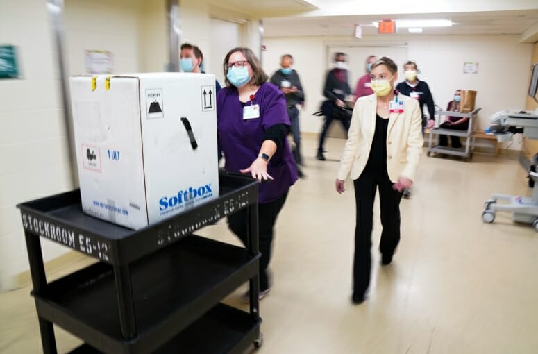 UW Health pharmacy technicians walk COVID-19 vaccine down the hall