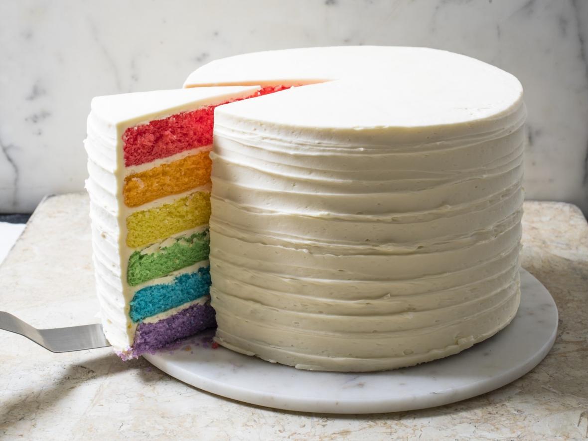 Rainbow cake being sliced