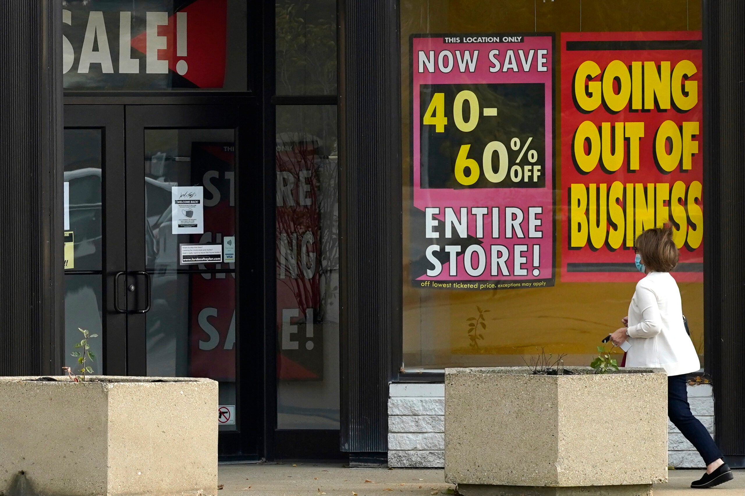 A shopper wears a face mask as she walks into a department store