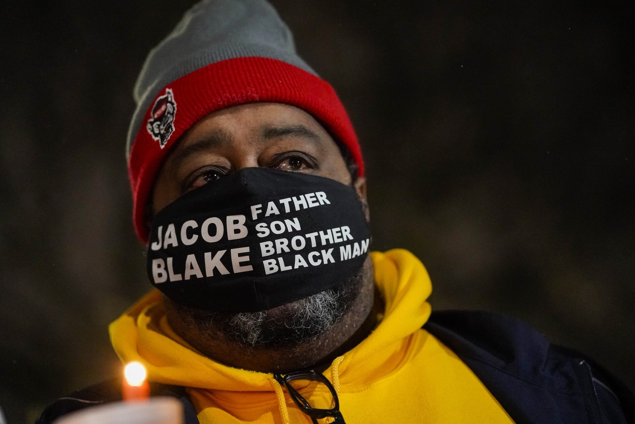 Jacob Blake Sr., father of Jacob Blake, holds a candle at a rally