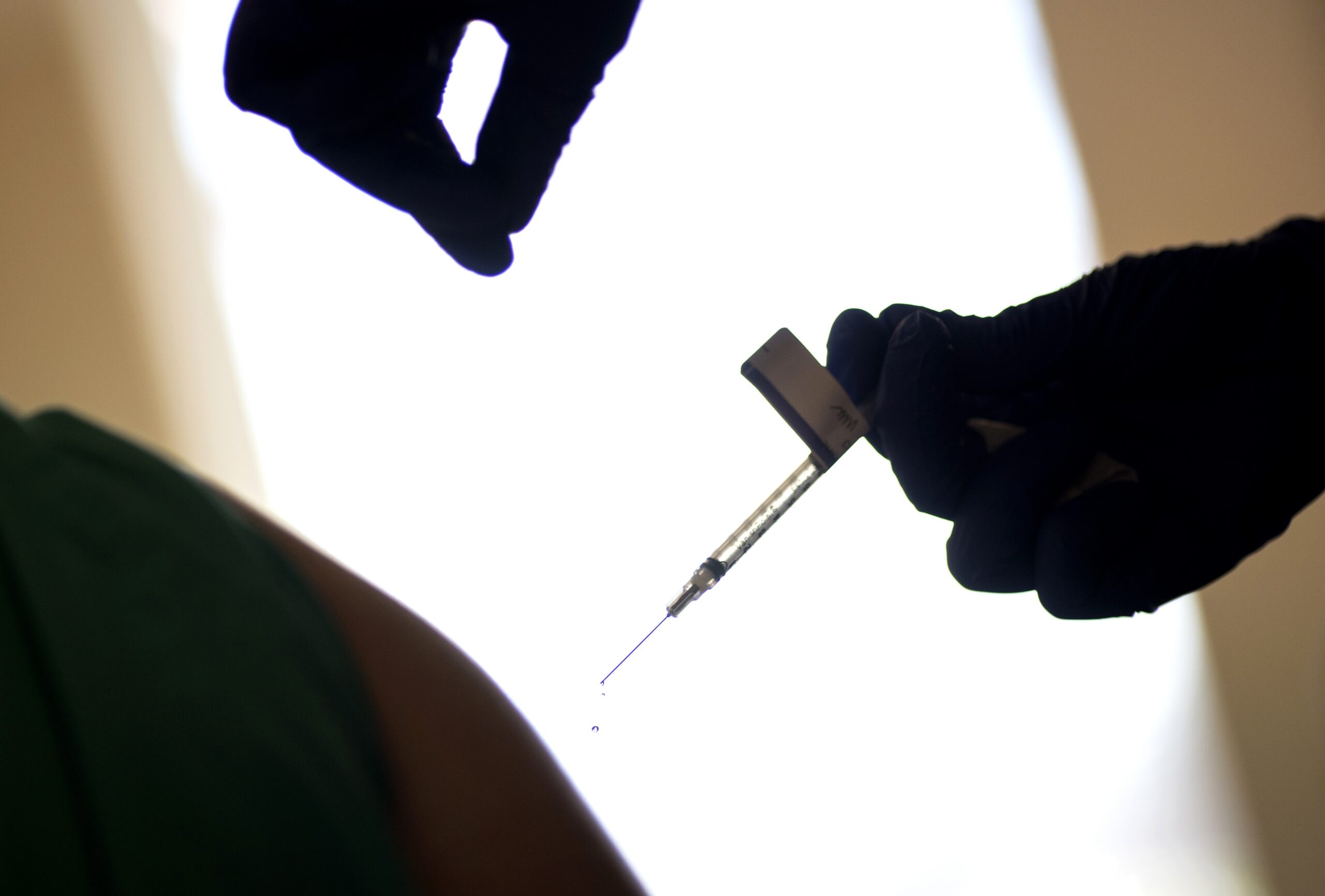 A droplet falls from a syringe after a health care worker was injected with the Pfizer-BioNTech COVID-19 vaccine