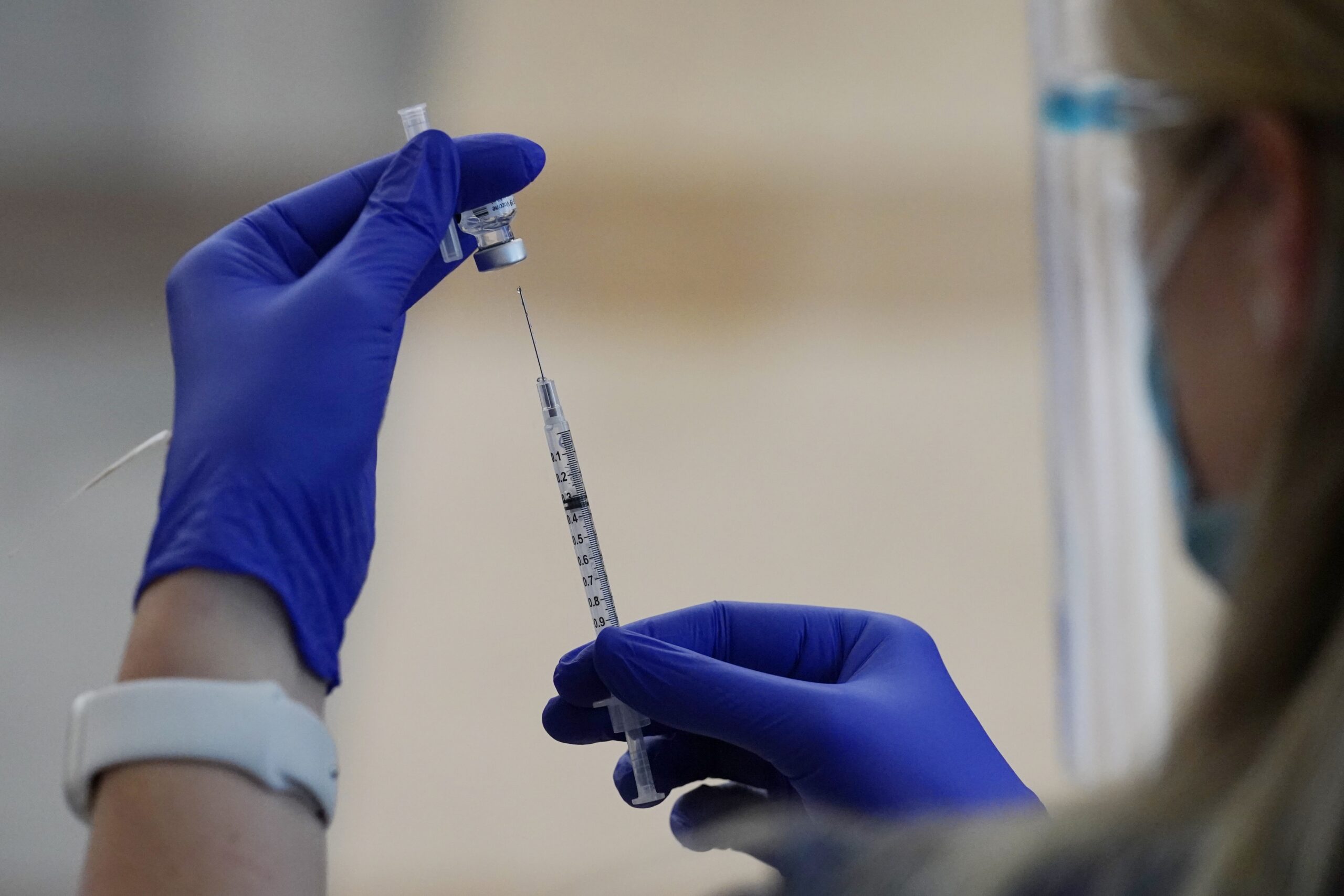 A nurse draws Pfizer's coronavirus vaccine into a syringe