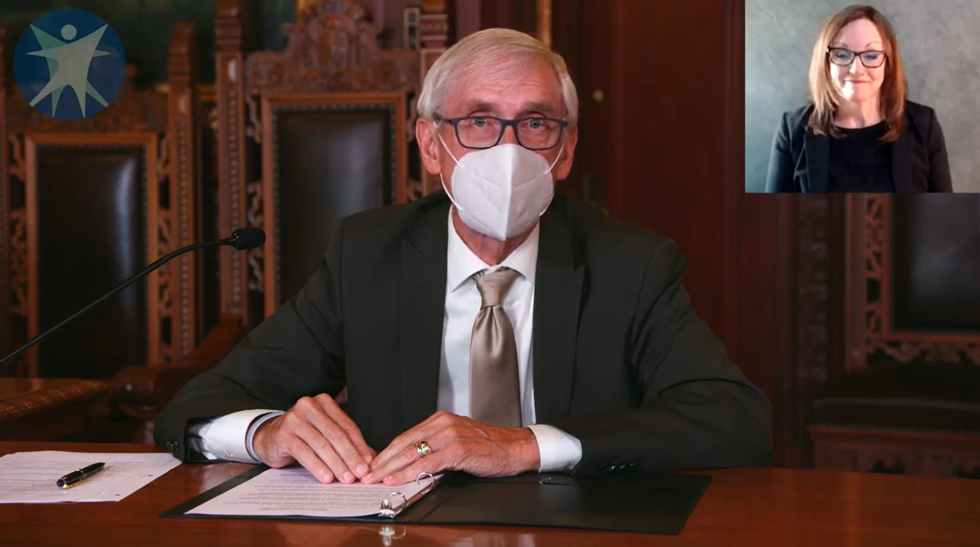 Governor Tony Evers addresses the public while wearing a mask