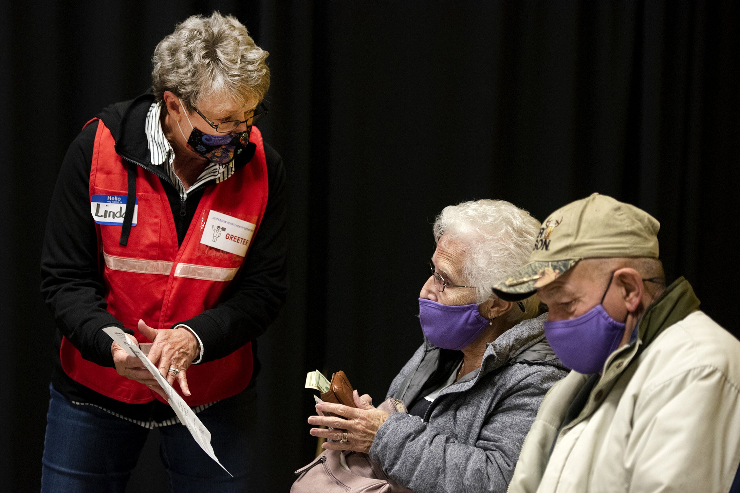 a greeter presents information to a couple sitting in an observation area