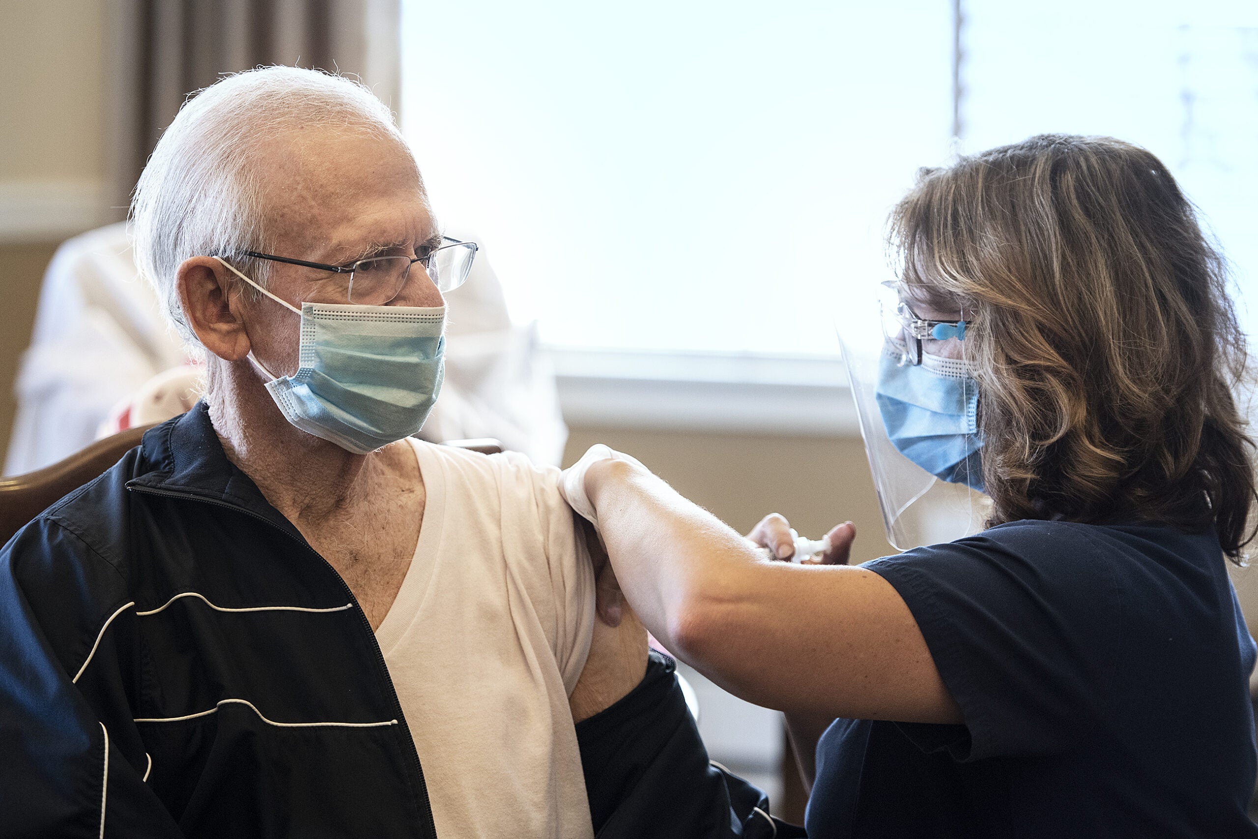 A man with his shirt pulled down receives a shot