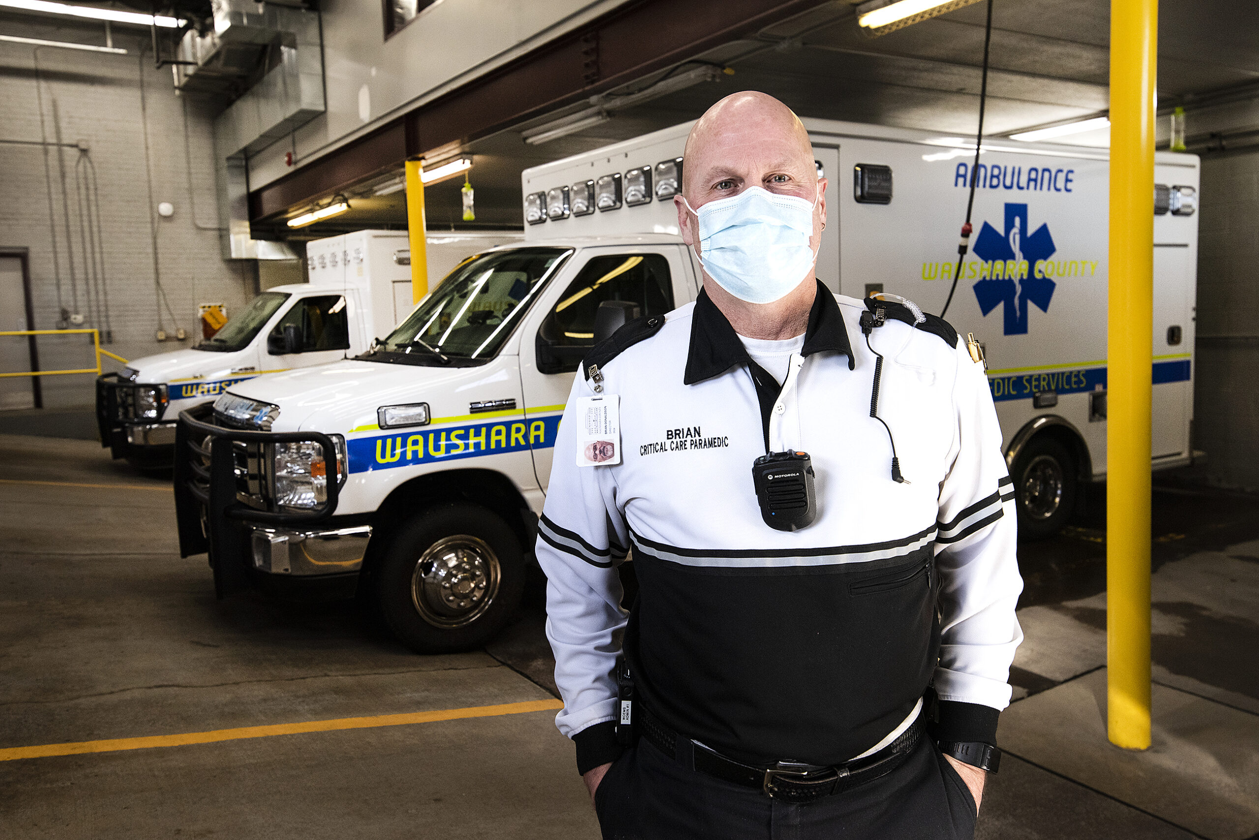 A man stands in the ambulance garage area.