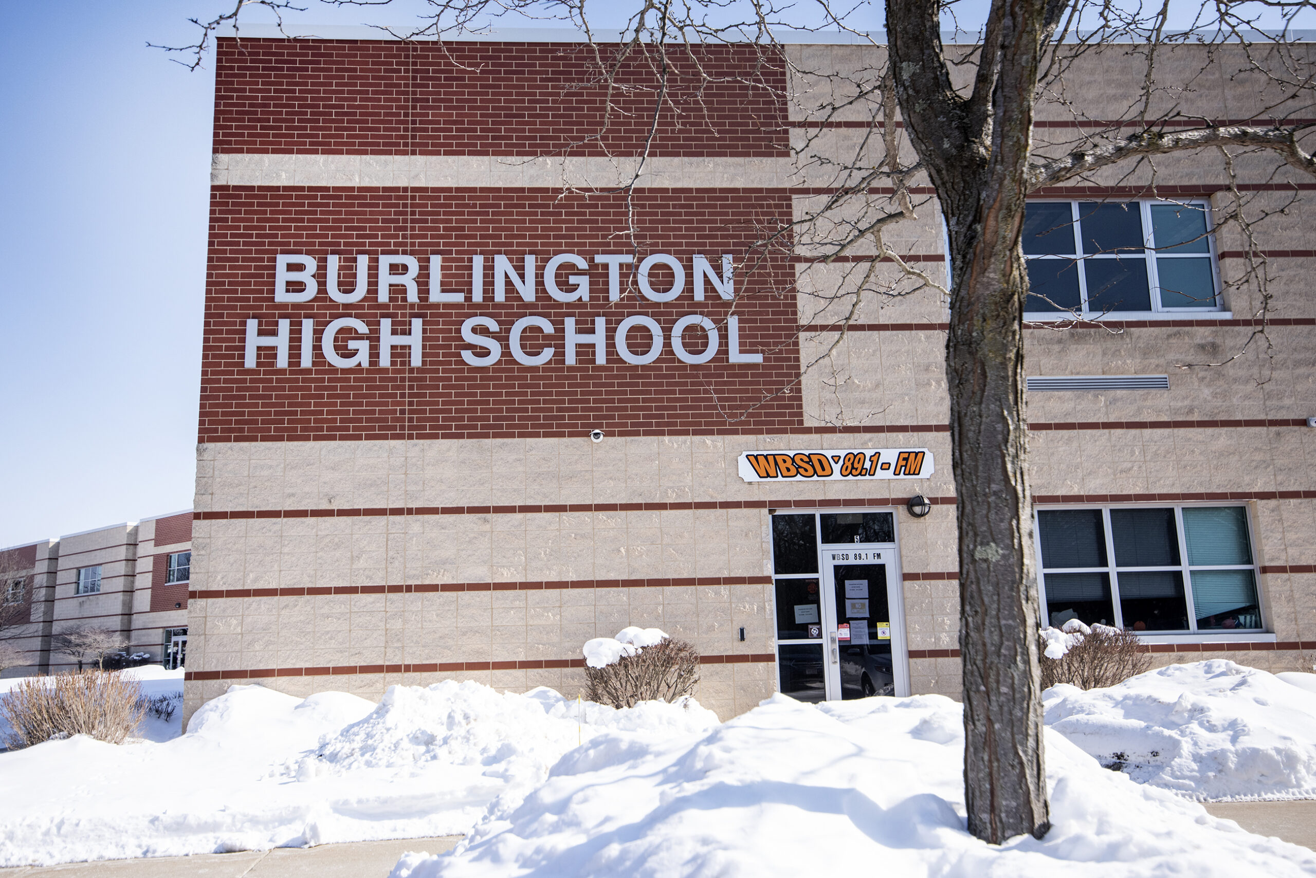 A building with red brick has the words "Burlington High School" on the side.