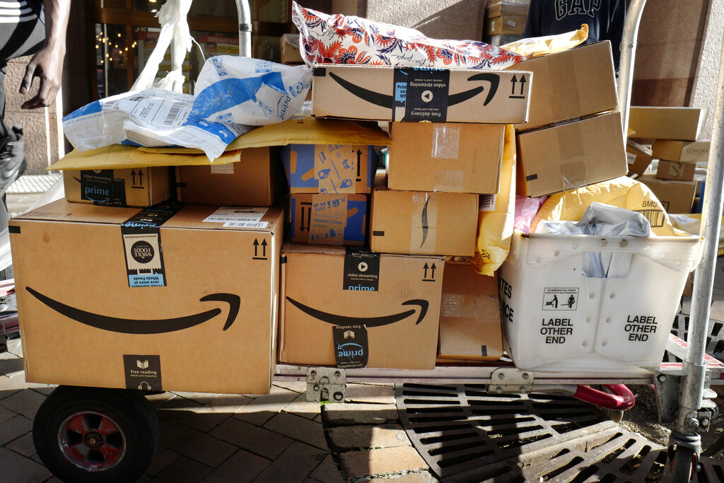 A pile of Amazon packages are loaded on a cart for delivery.