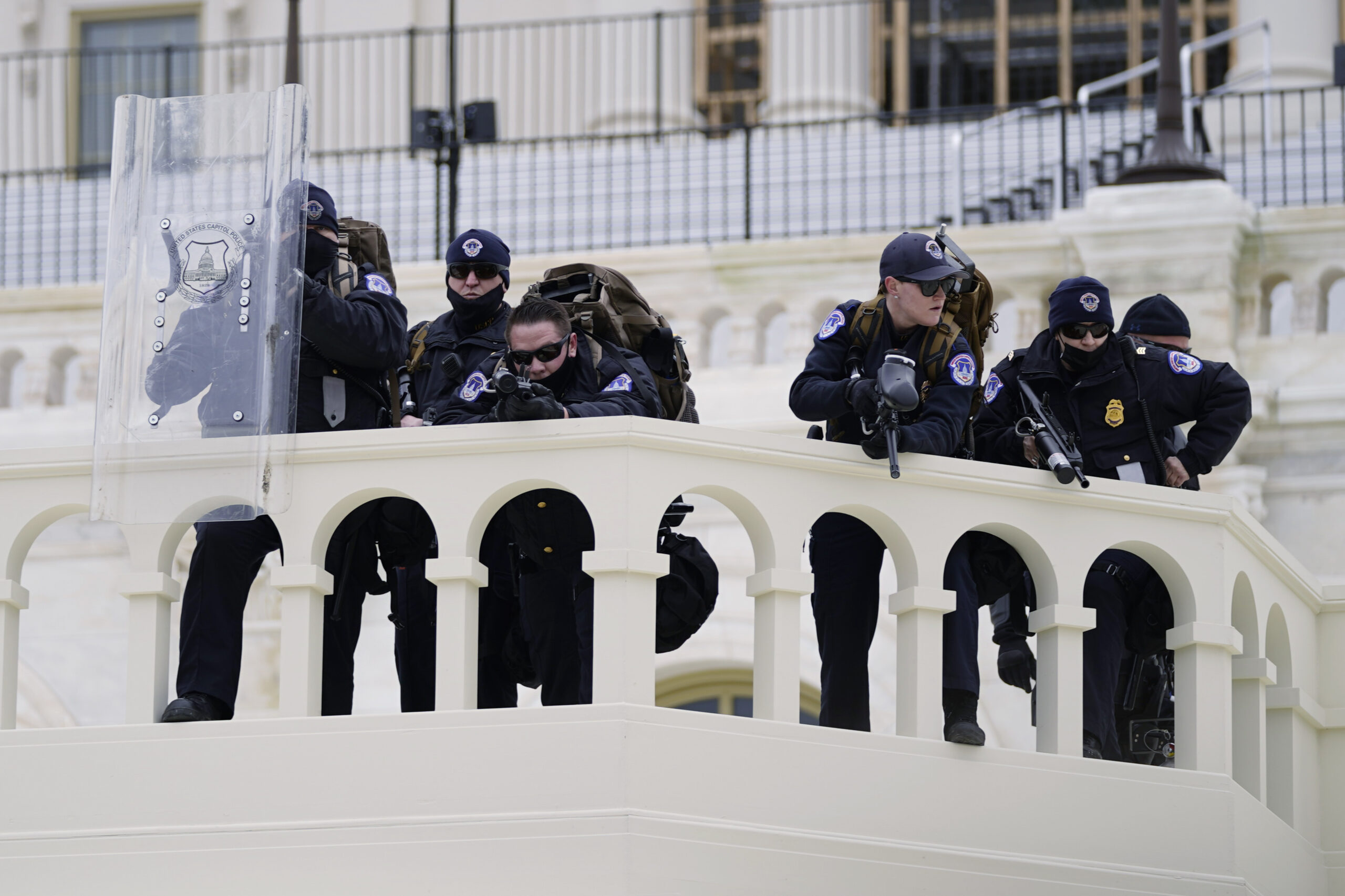 Police keep a watch on demonstrators who tried to break through a police barrier, Wednesday, Jan. 6, 2021