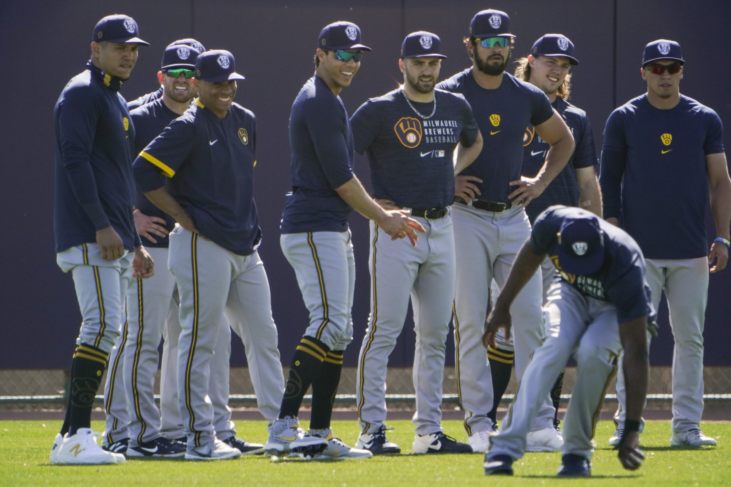 Milwaukee Brewers teammates watch as Lorenzo Cain fields a ball during practice