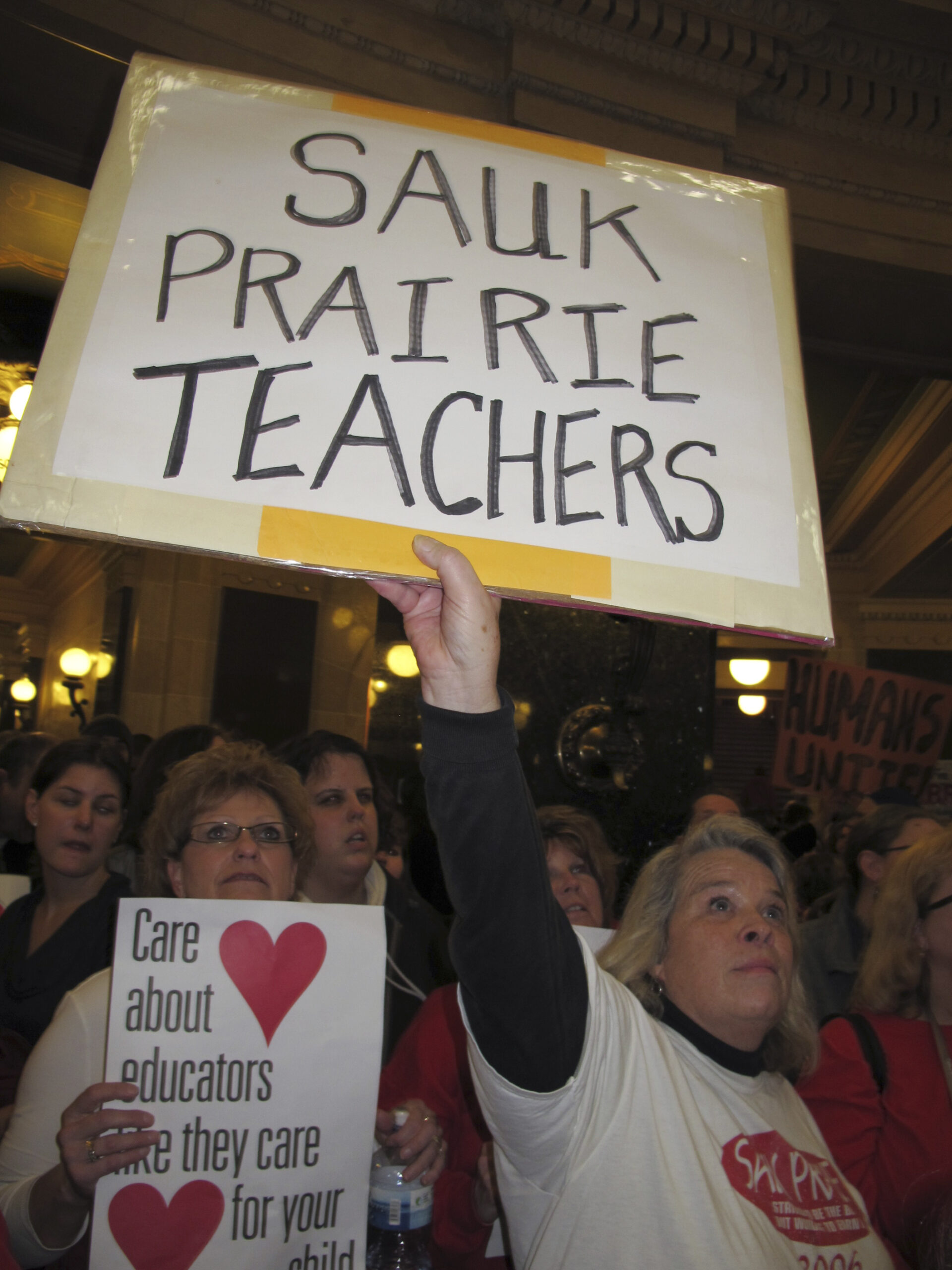Teacher holding a protest sign