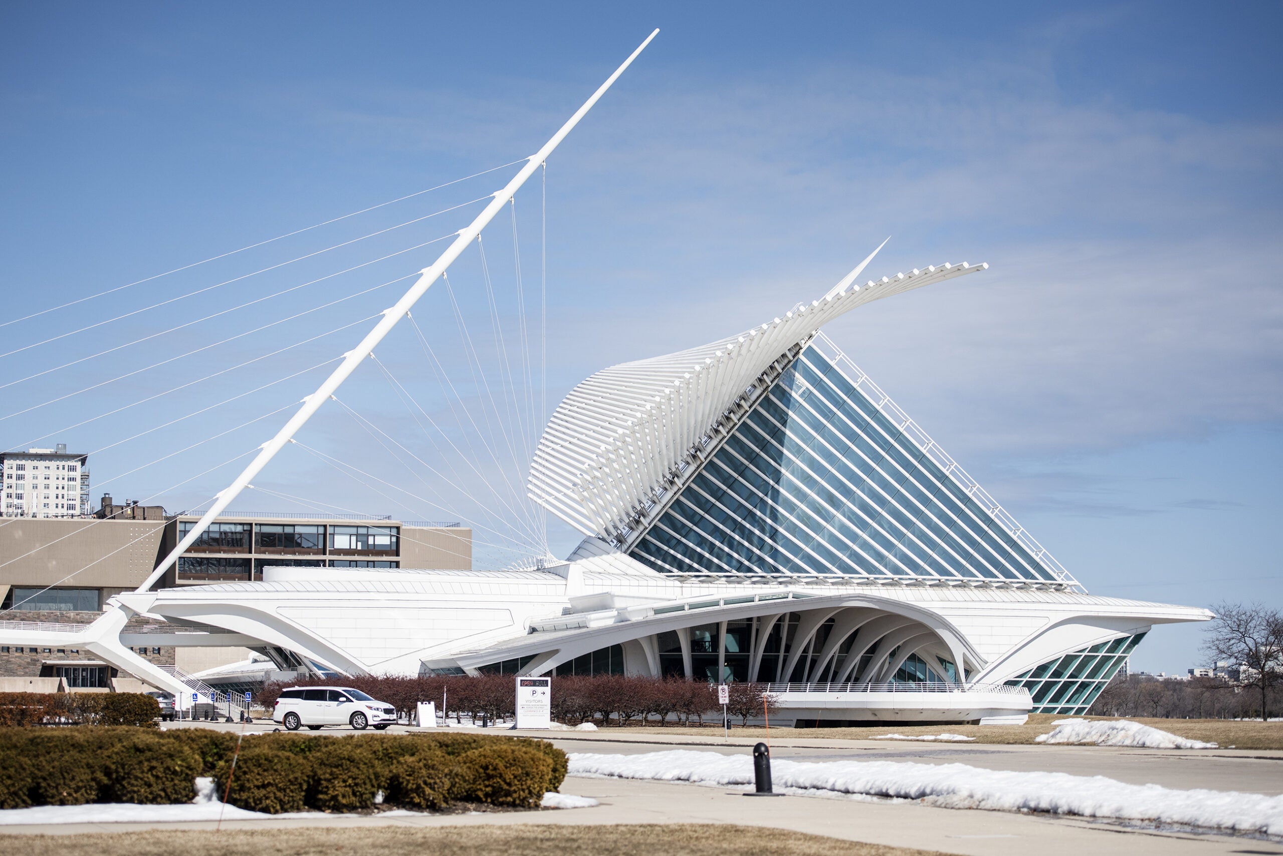 The wings of the Milwaukee Art Museum are seen from the outside backdropped by a blue sky.