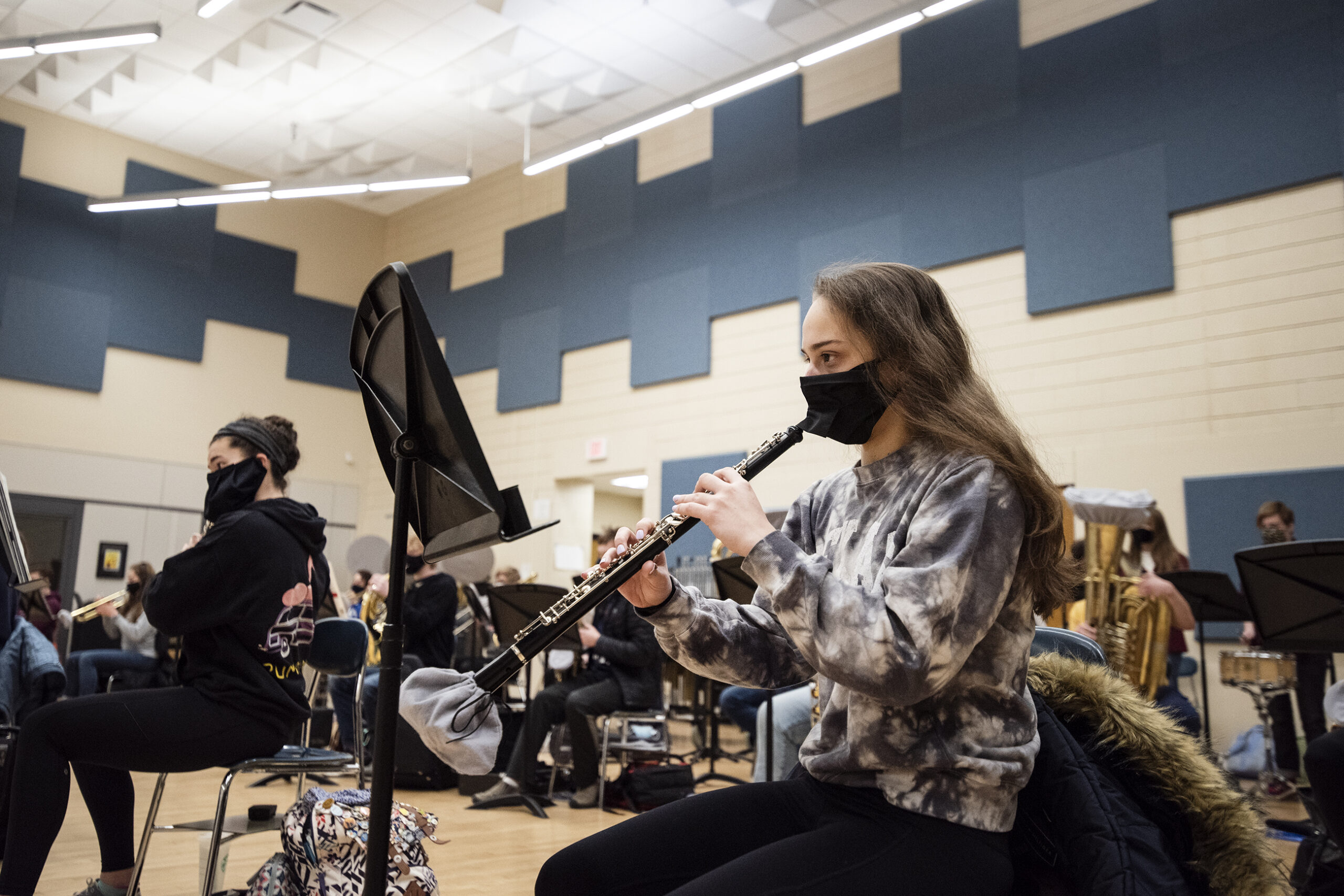 A student wears a face mask as she plays the clarinet.