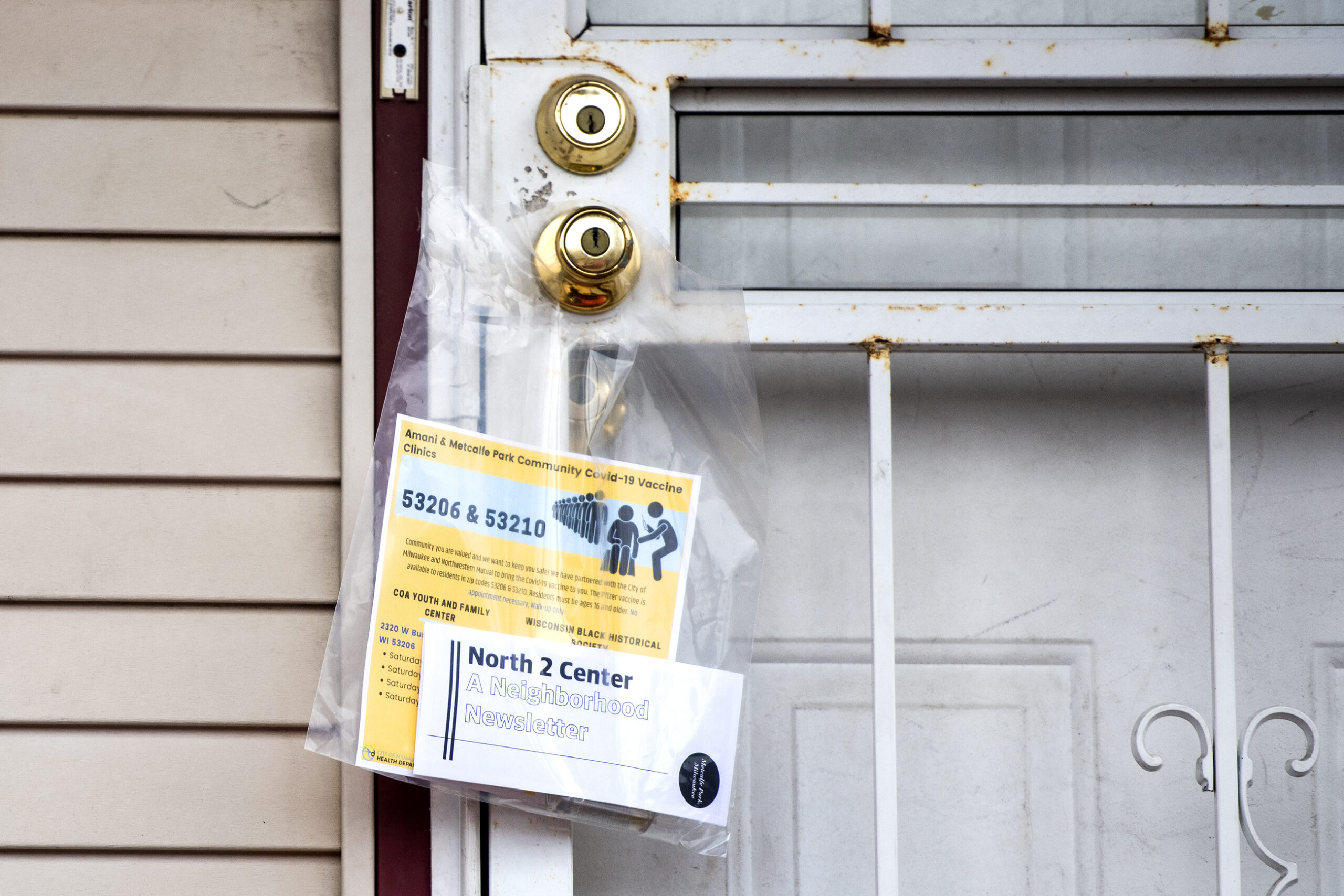 A plastic bag containing informational paperwork hangs on a doorknob.