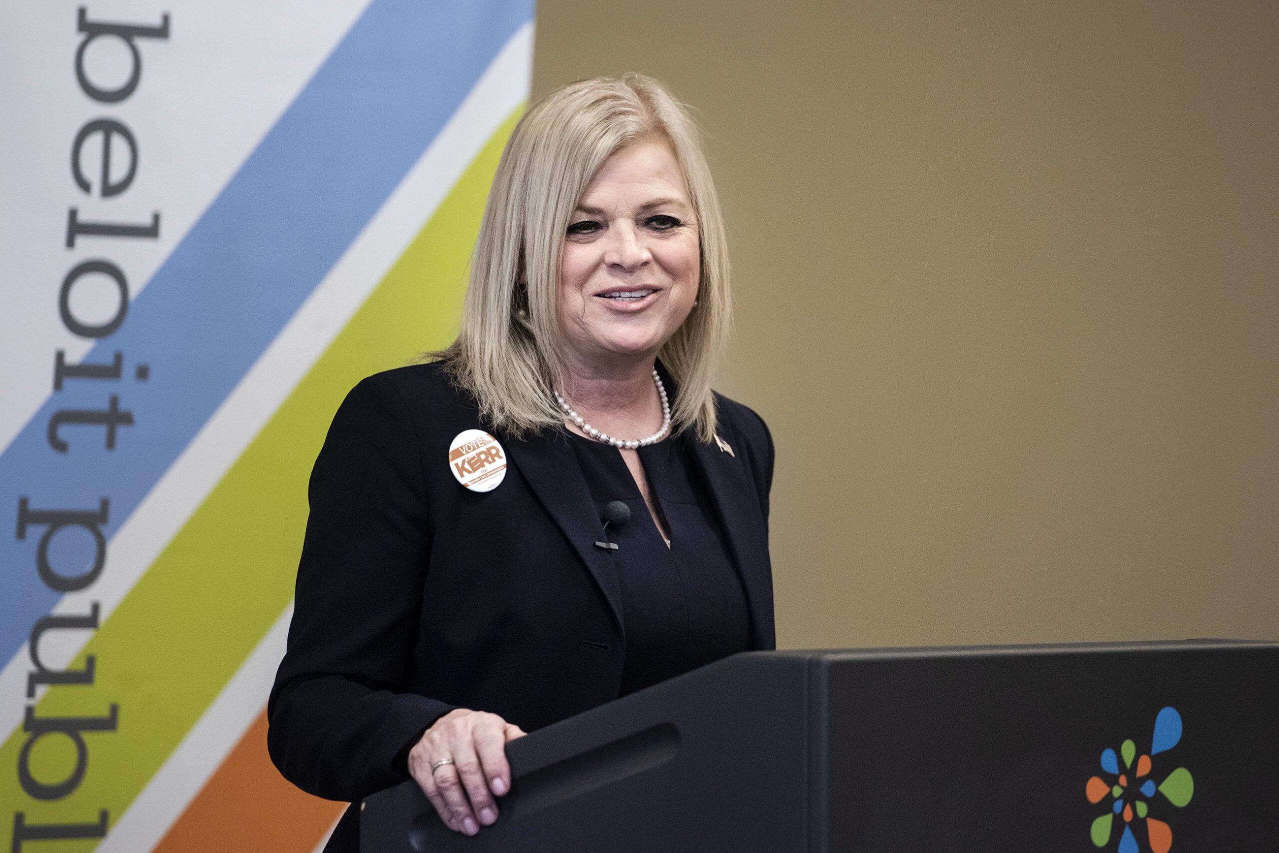 A woman speaks at a lectern.