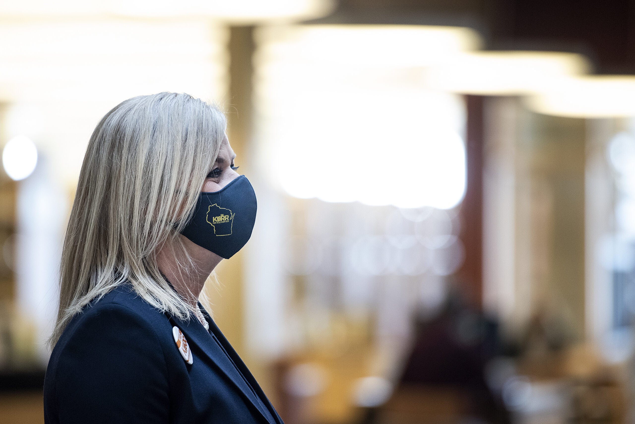 A woman wears a mask that says 