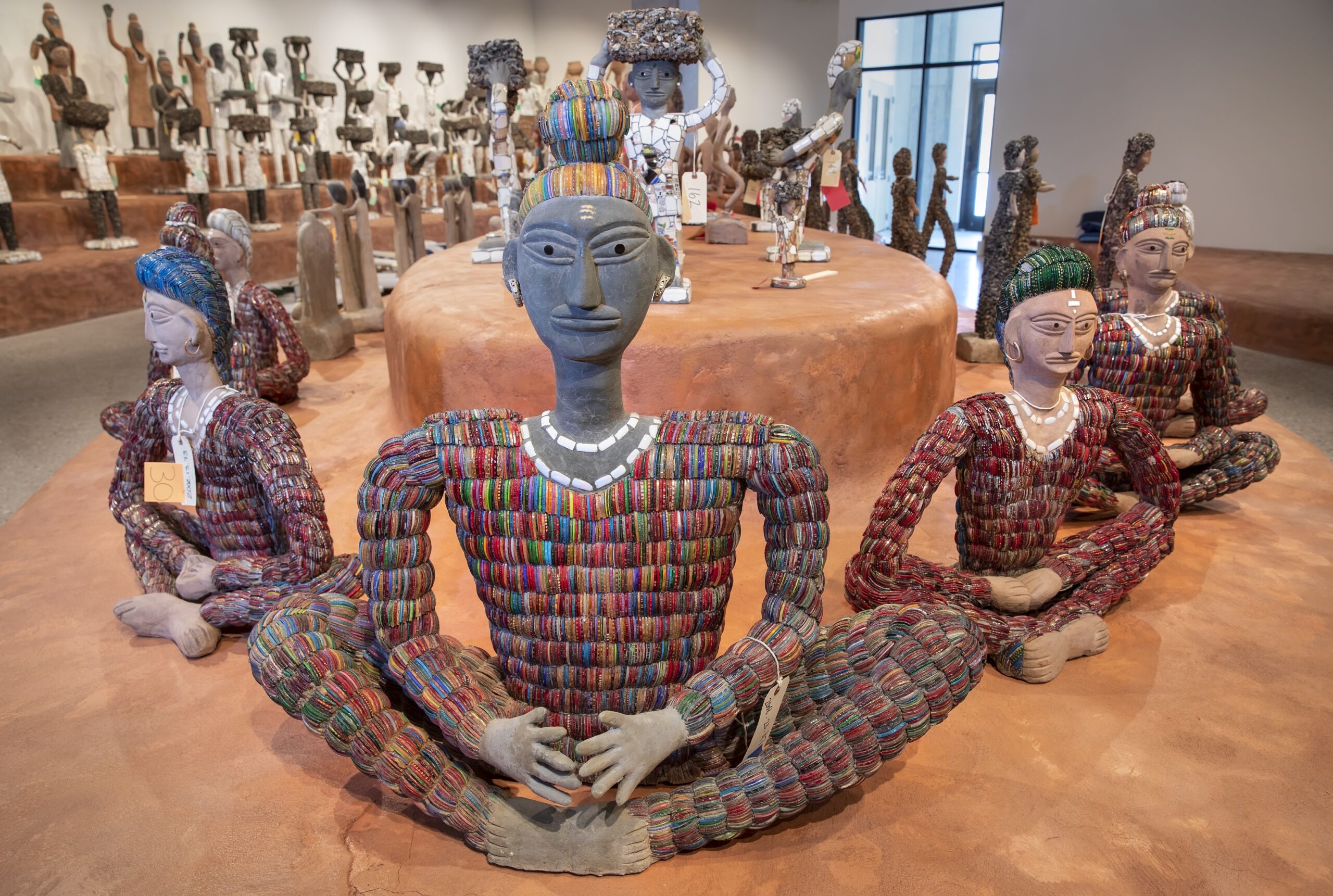 Works by Nek Chand, arranged on tiered platforms at the Art Preserve
