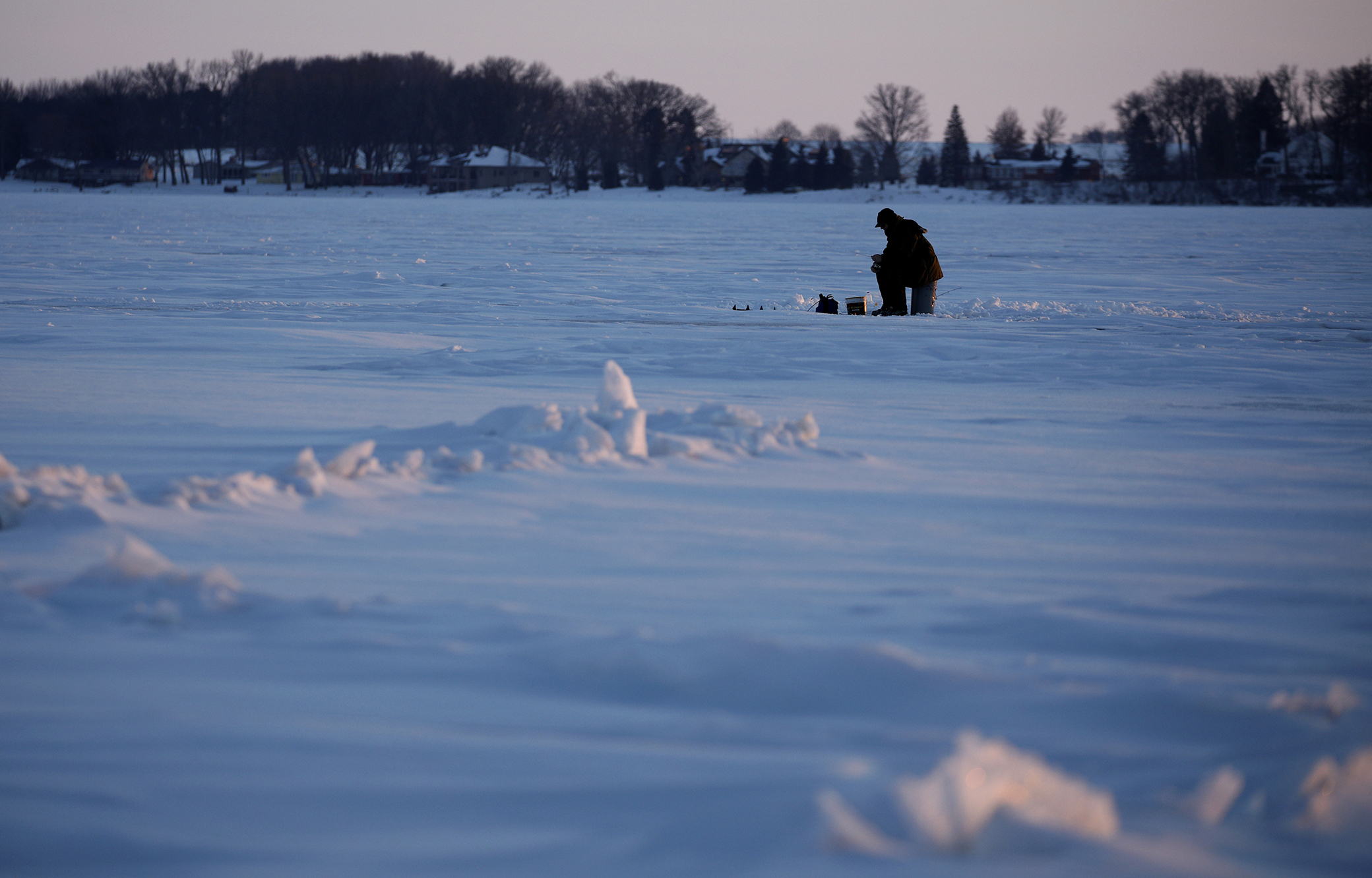 An ice fisherman fishes on Storm Lake in Storm Lake, Iowa