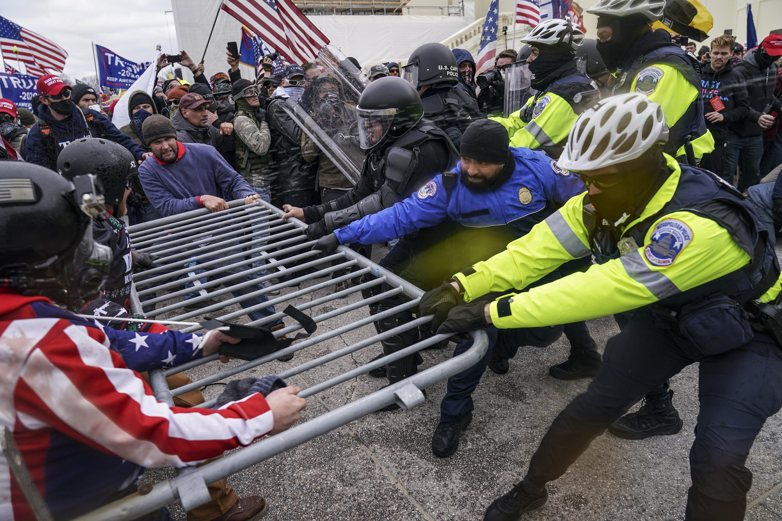 photo rioters try to break through a police barrier at the Capitol in Washington